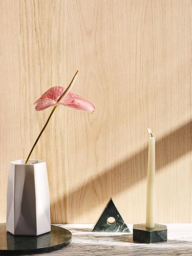 Green Triangle Stone Candle Holders on Stone Countertop and Ceramic Vase