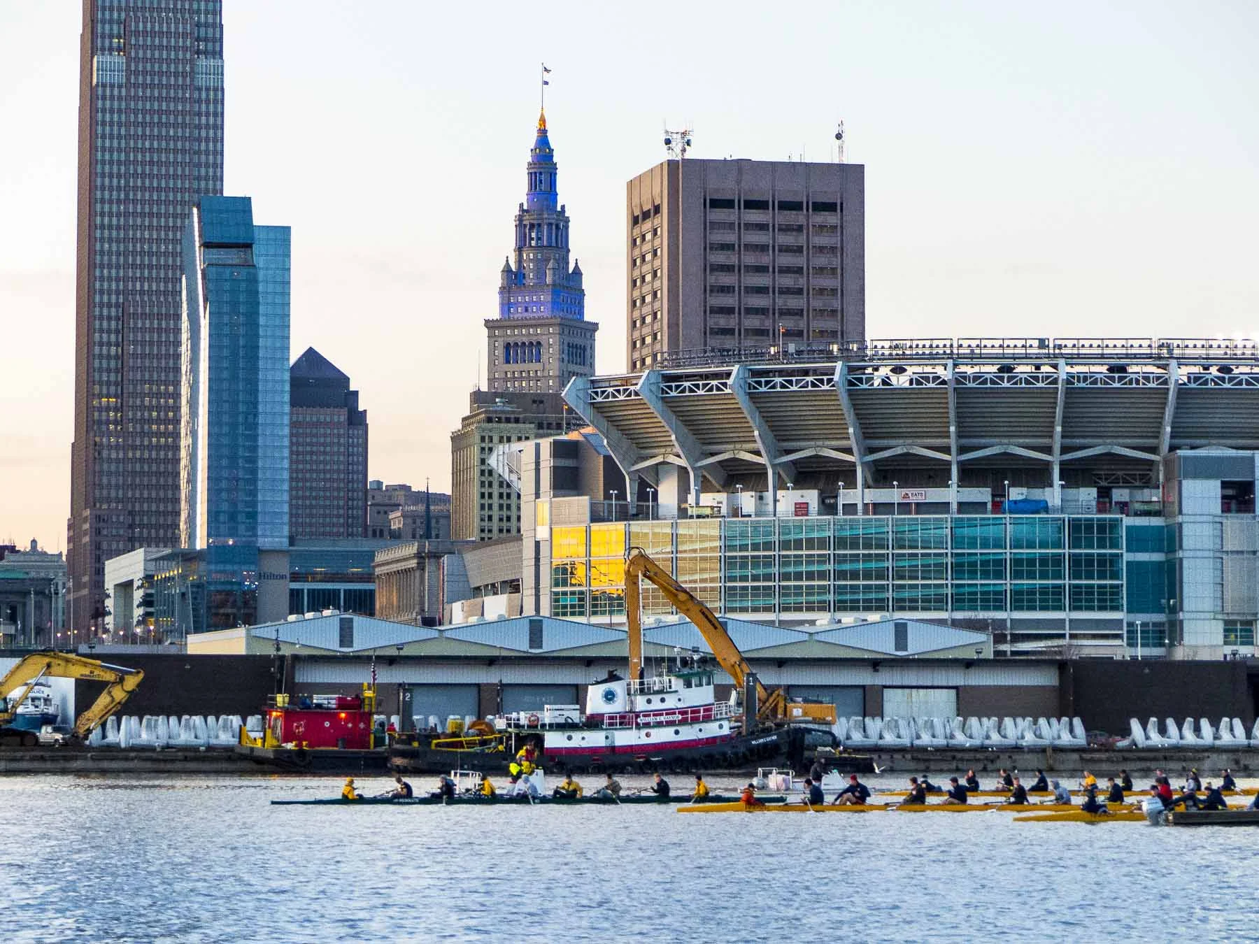 Rowing shells line up in front of Port of Cleveland docks where dolos await transport to the U.S. Army Corps Cleveland Harbor East breakwall repair project