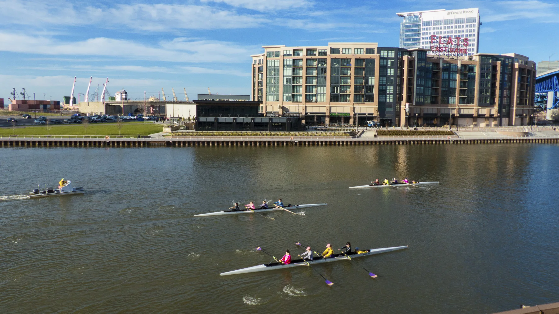 Rowers from St. Joseph Academy passing the Flats East Bank development