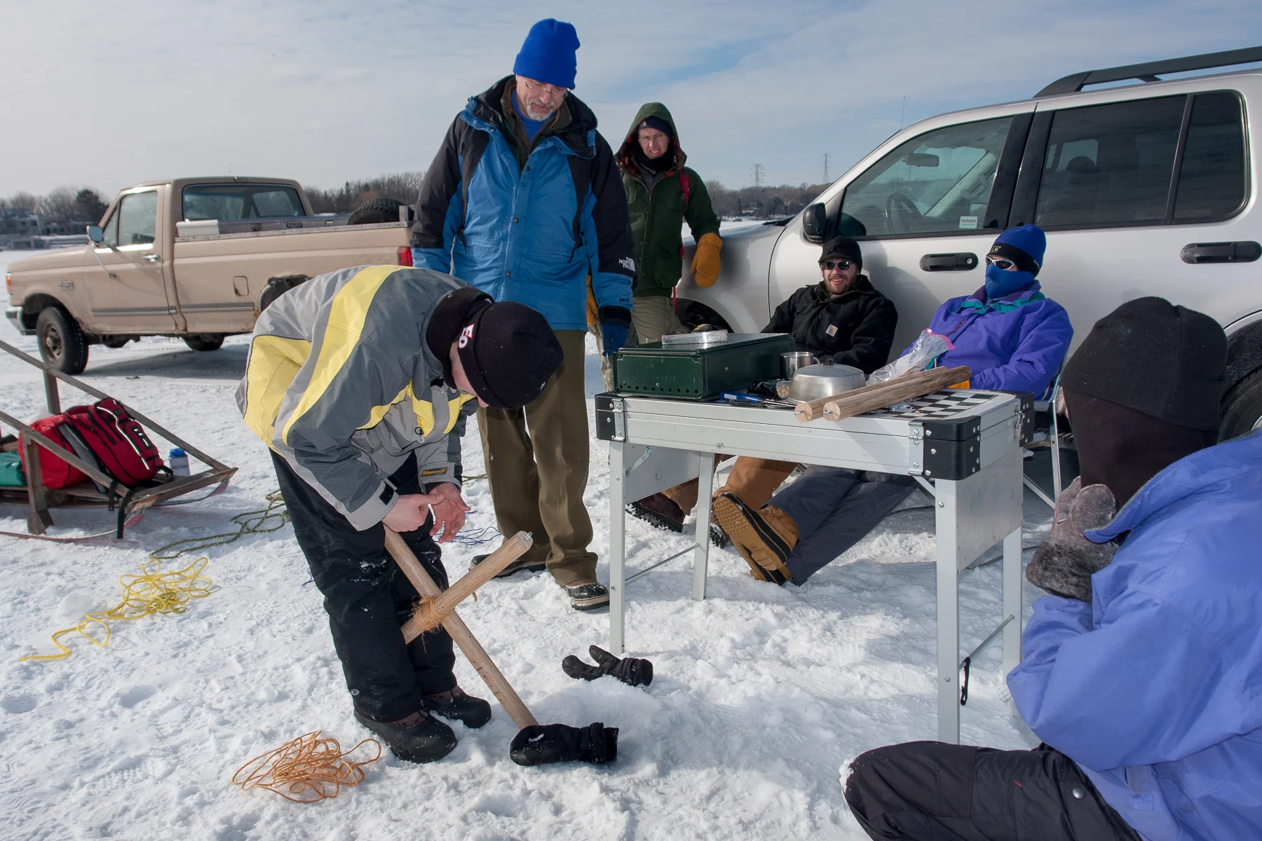 Poles were lashed together to form a cross to hold the hook. Ropes were attached to the ends of the poles to suspend the hook over the ice bucket.