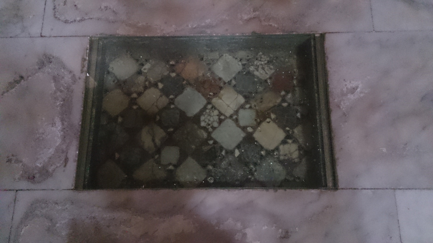 Glass over a collection of colourful tiles set into the floor of the sanctuary Viterbo cathedral