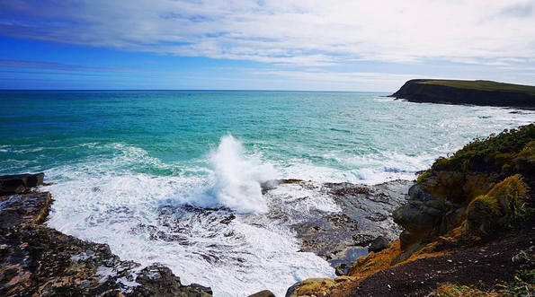 WAVES CRASH INTO THE COASTLINE DOWN AT CURIO BAY, NEW ZEALAND