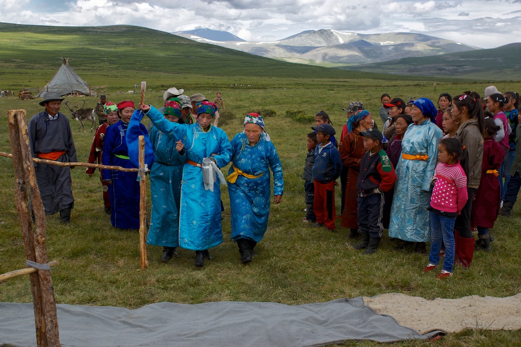 Guided and supported by her mother in law and sister in law, Solongo blesses her new home by spraying milk and circling around it 3 times.