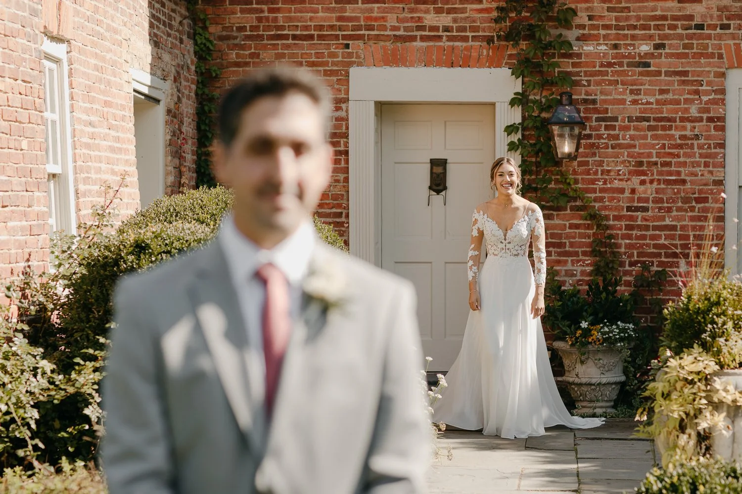 Bride walking toward groom for their first look outside Windrift Hall during a Hudson Valley wedding
