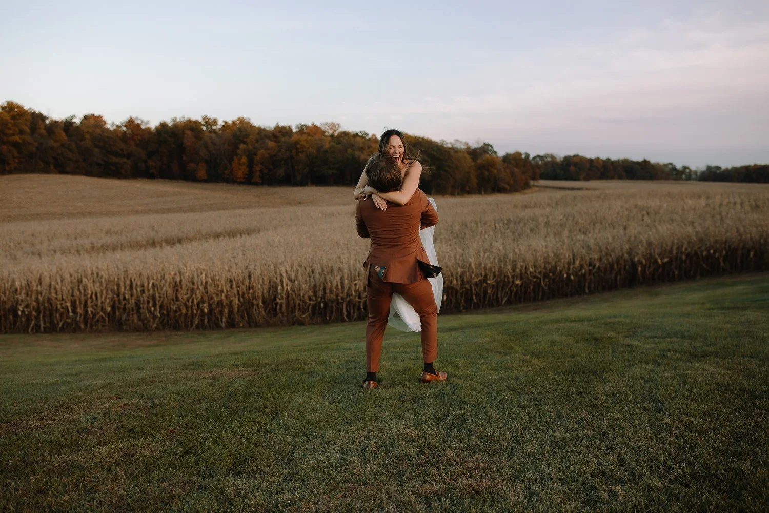 Newlyweds sharing a joyful sunset moment in an open field at Ivory Meadows wedding venue in Dayton, Ohio.