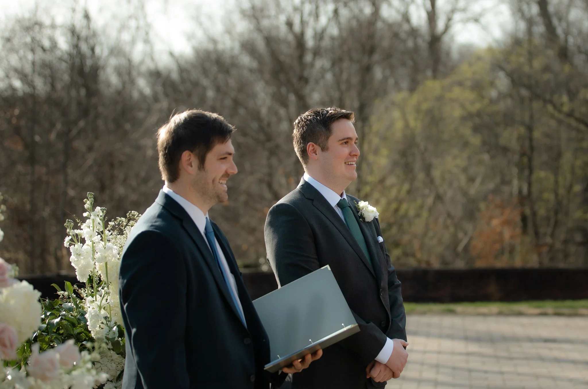 Groom and officiant waiting as ceremony begins on terrace