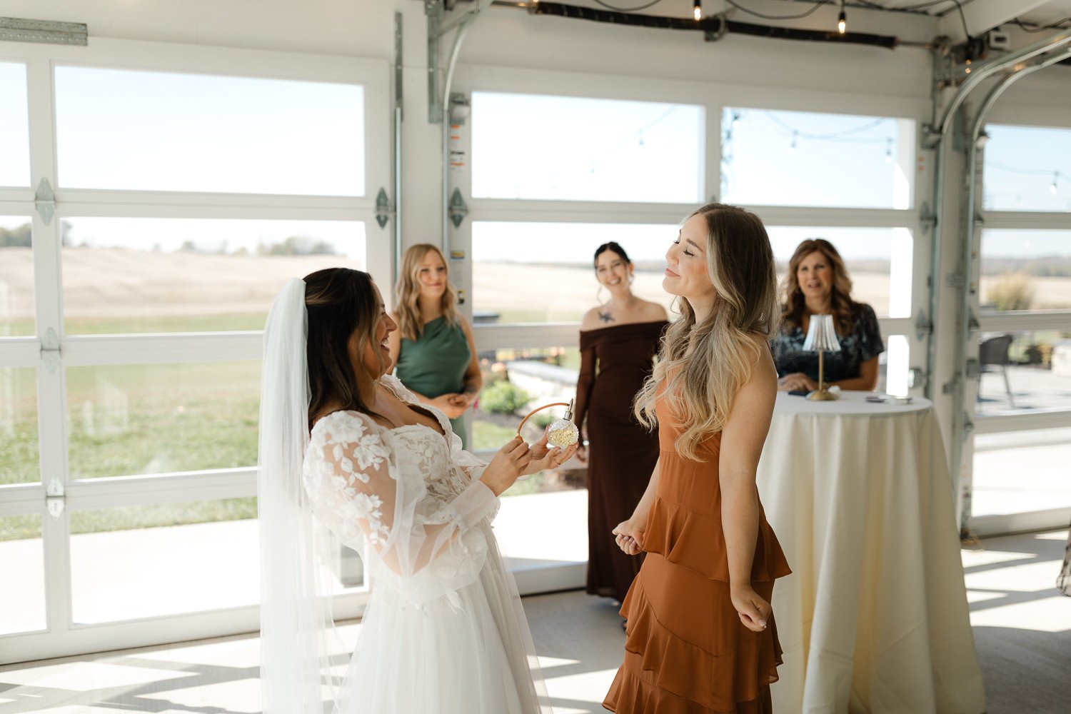Bride sharing a lighthearted moment with a bridesmaid during getting ready at Ivory Meadows in Yellow Springs, Ohio.