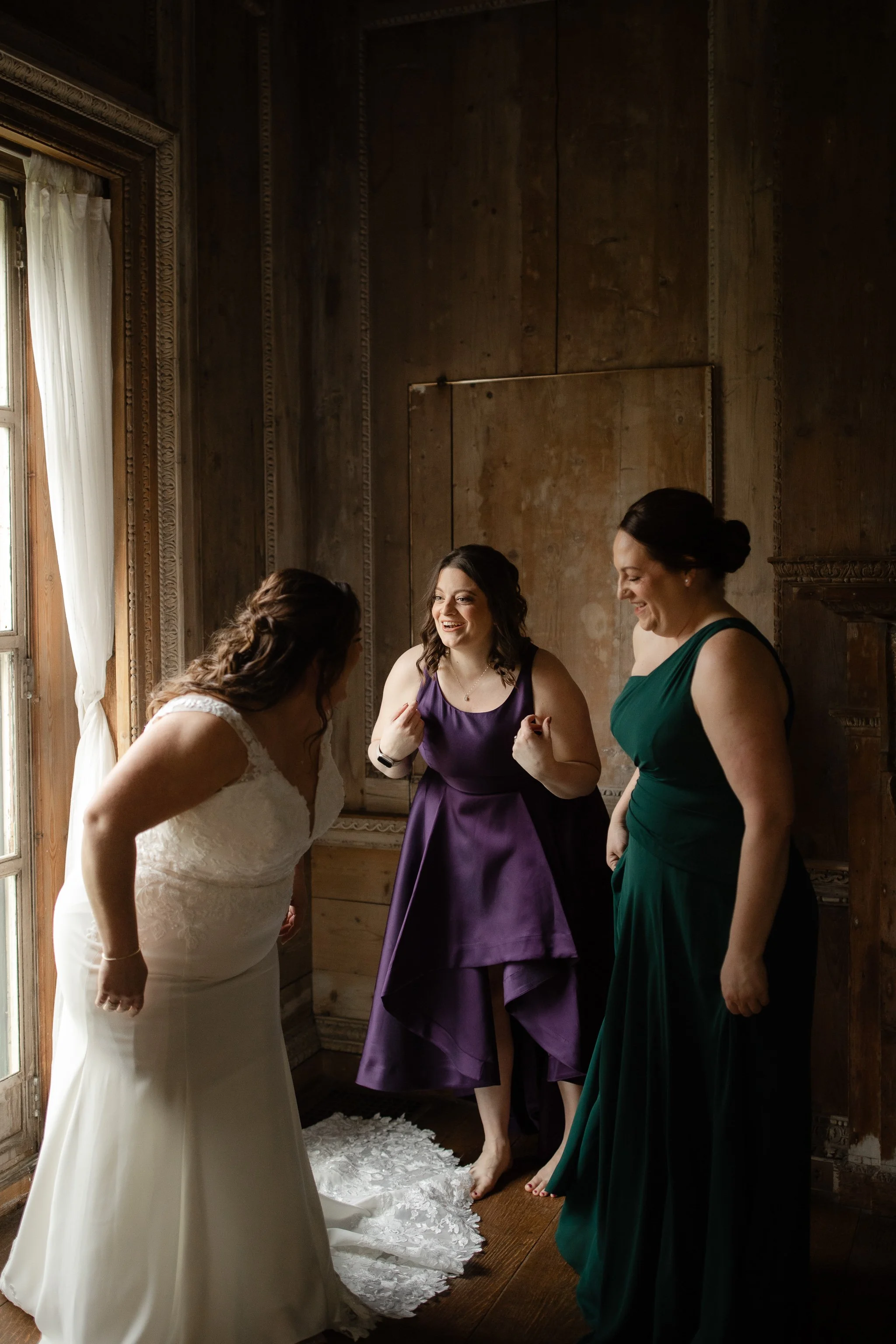 Bride laughing with friends while getting ready inside Peterloon Estate