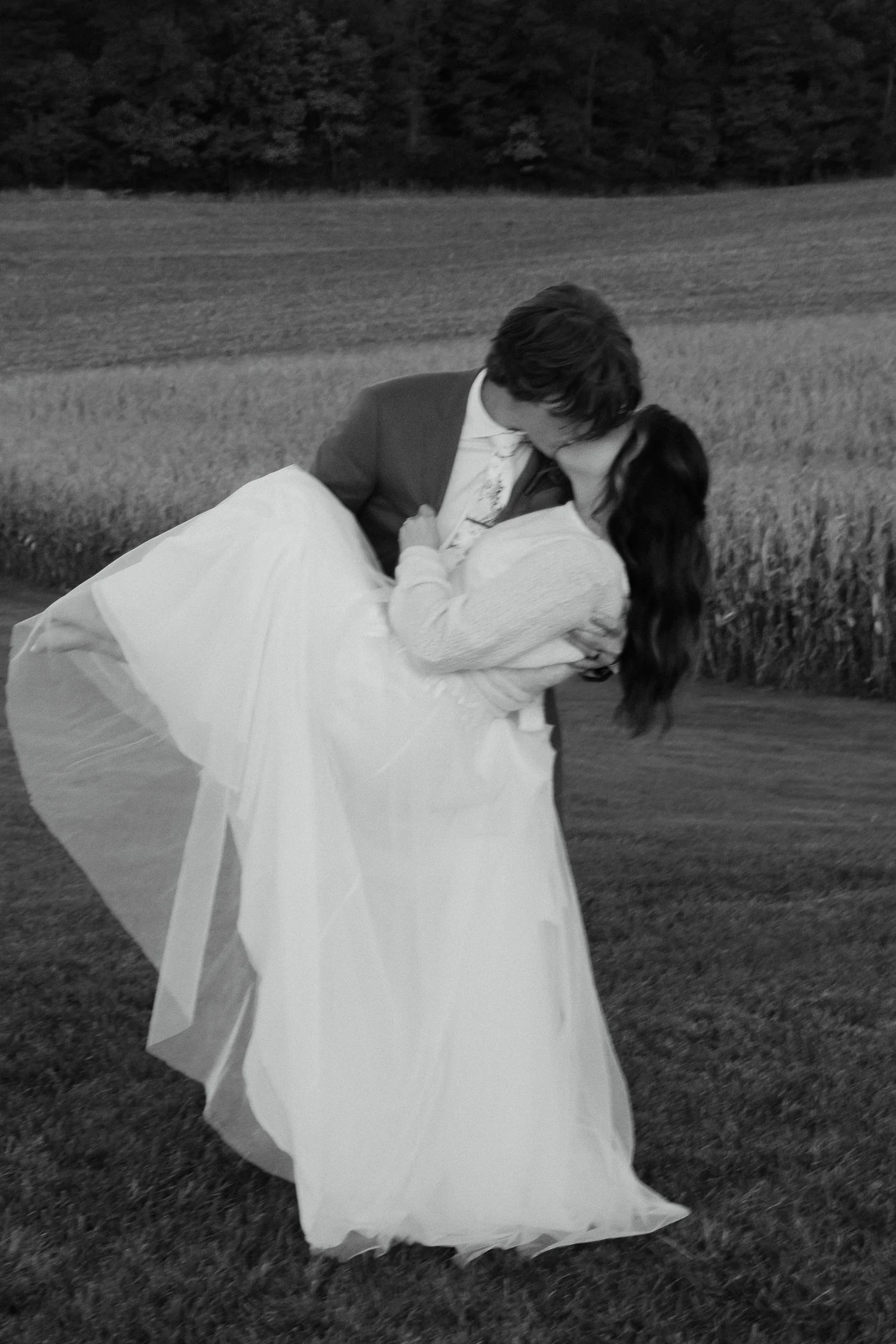 Bride and groom share a romantic dip and kiss during evening portraits at Ivory Meadows in Dayton, Ohio, photographed with a timeless film-inspired look.