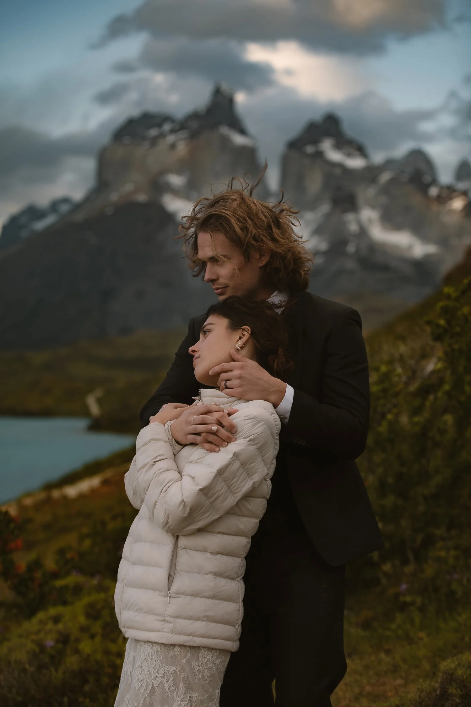 Couple embracing in dramatic mountain landscape during destination wedding portrait session
