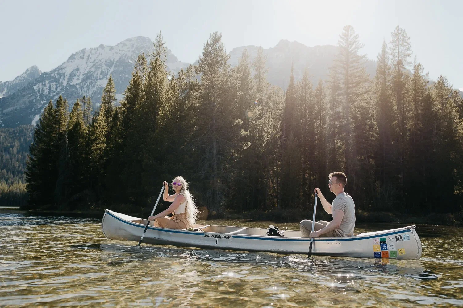 Couple canoeing on a mountain lake beneath the Grand Teton Range in Wyoming