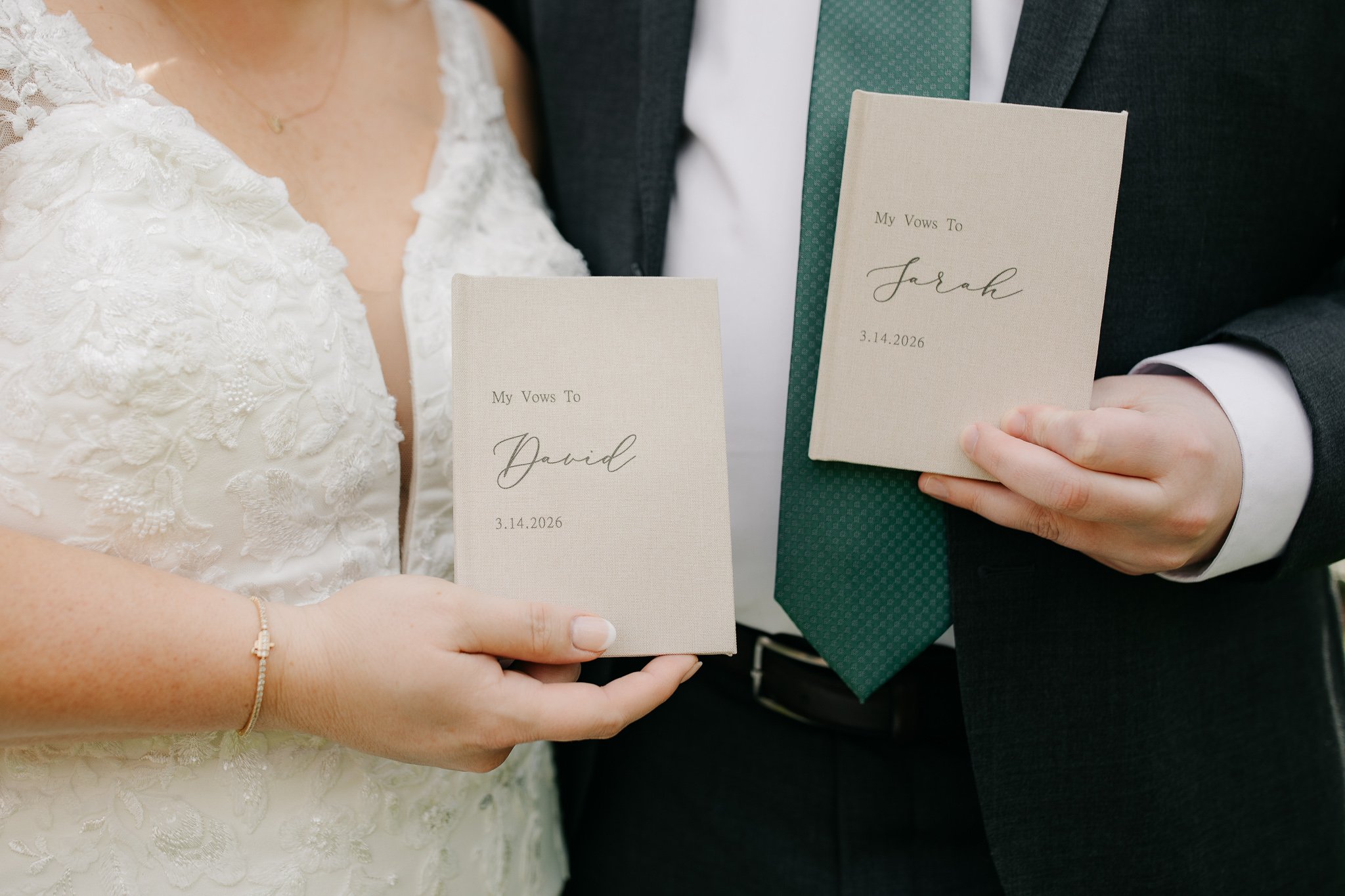 Bride and groom holding vow books during intimate wedding moment
