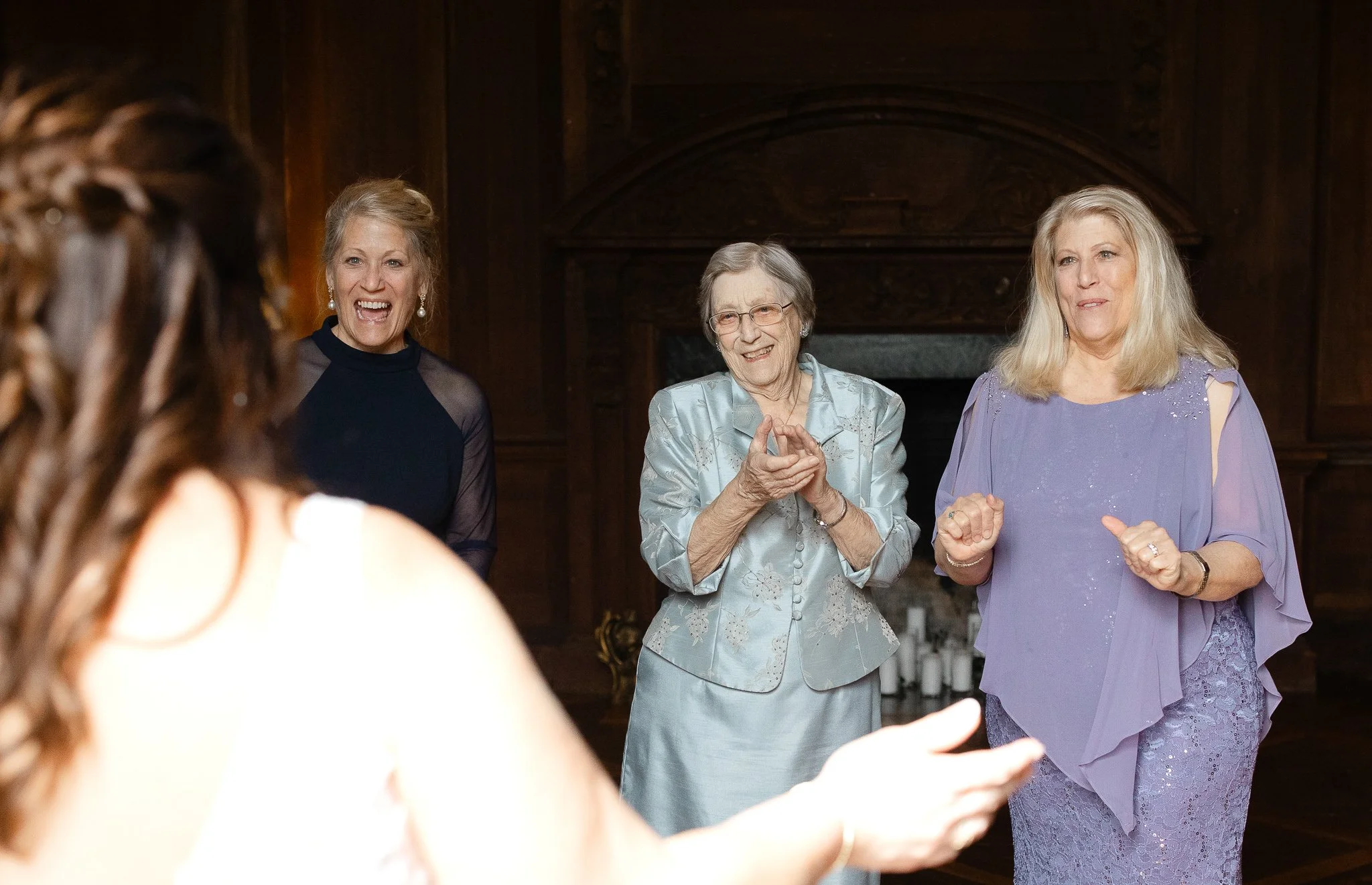Family members smiling and reacting during first look inside Peterloon Estate grand room