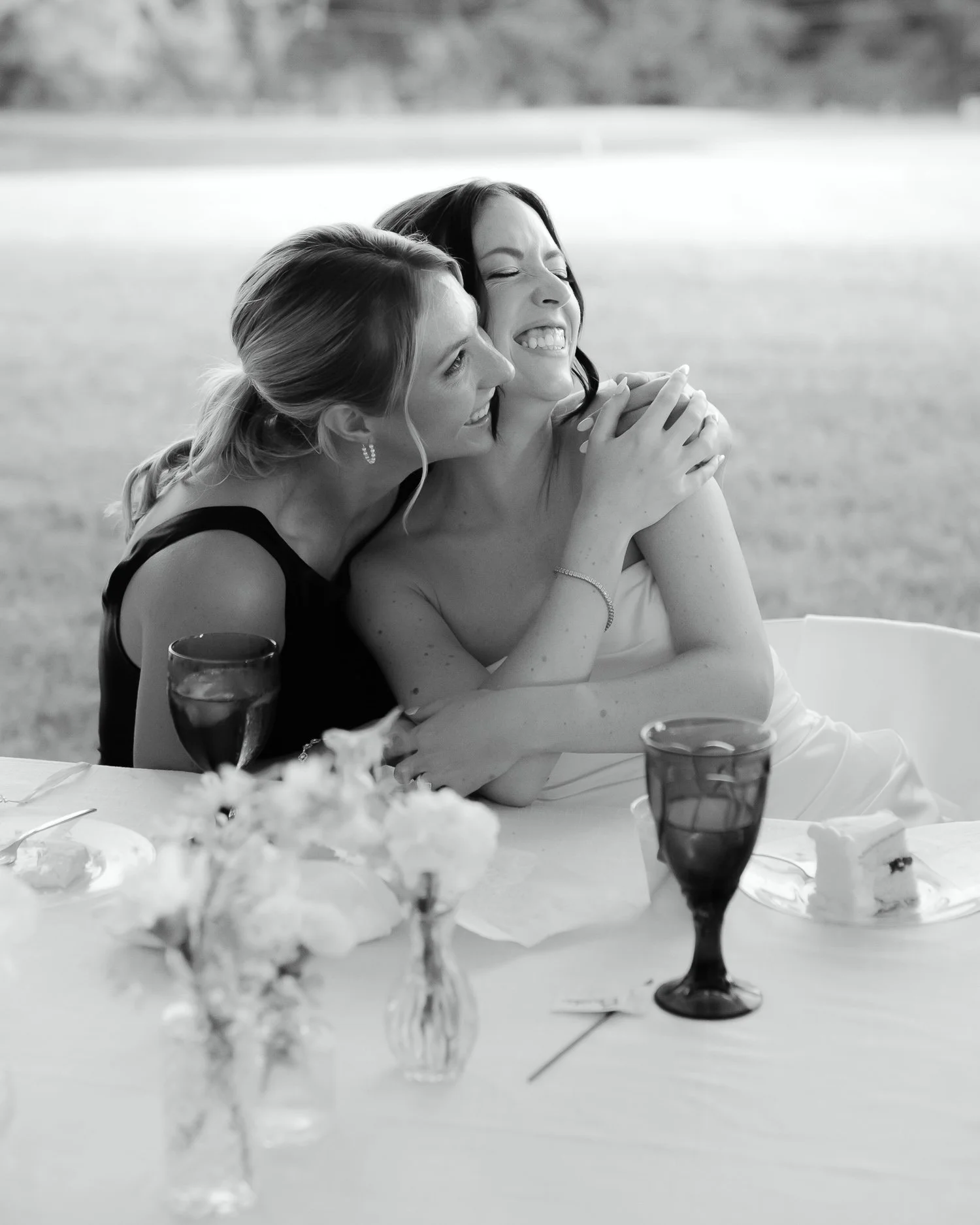 Bride sharing an emotional hug with a close friend during the wedding reception