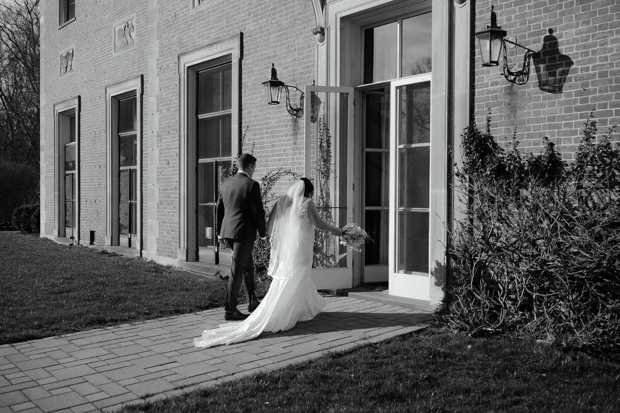 Bride and groom walking back toward estate after ceremony