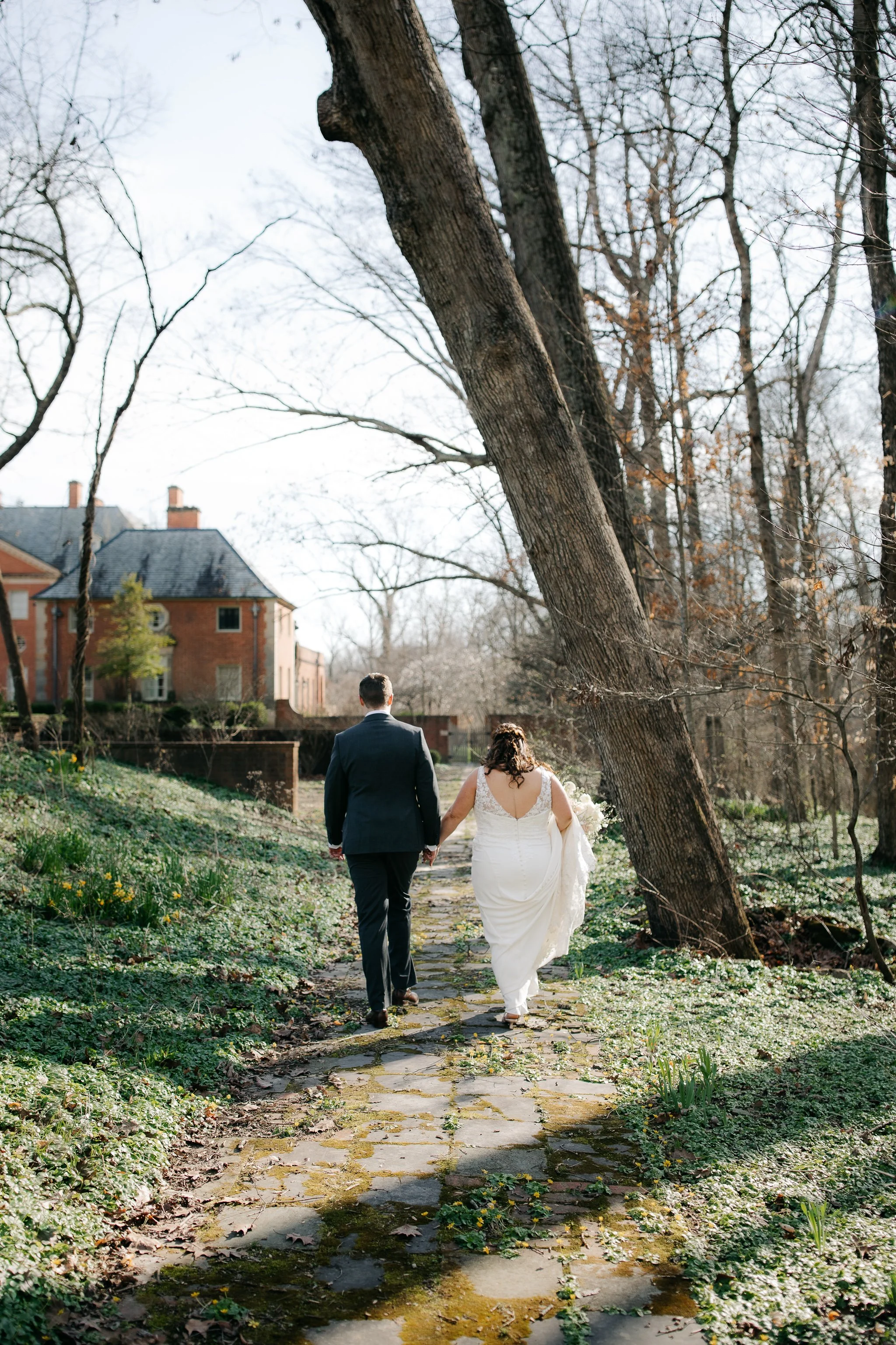 Bride and groom walking away together along garden path during wedding