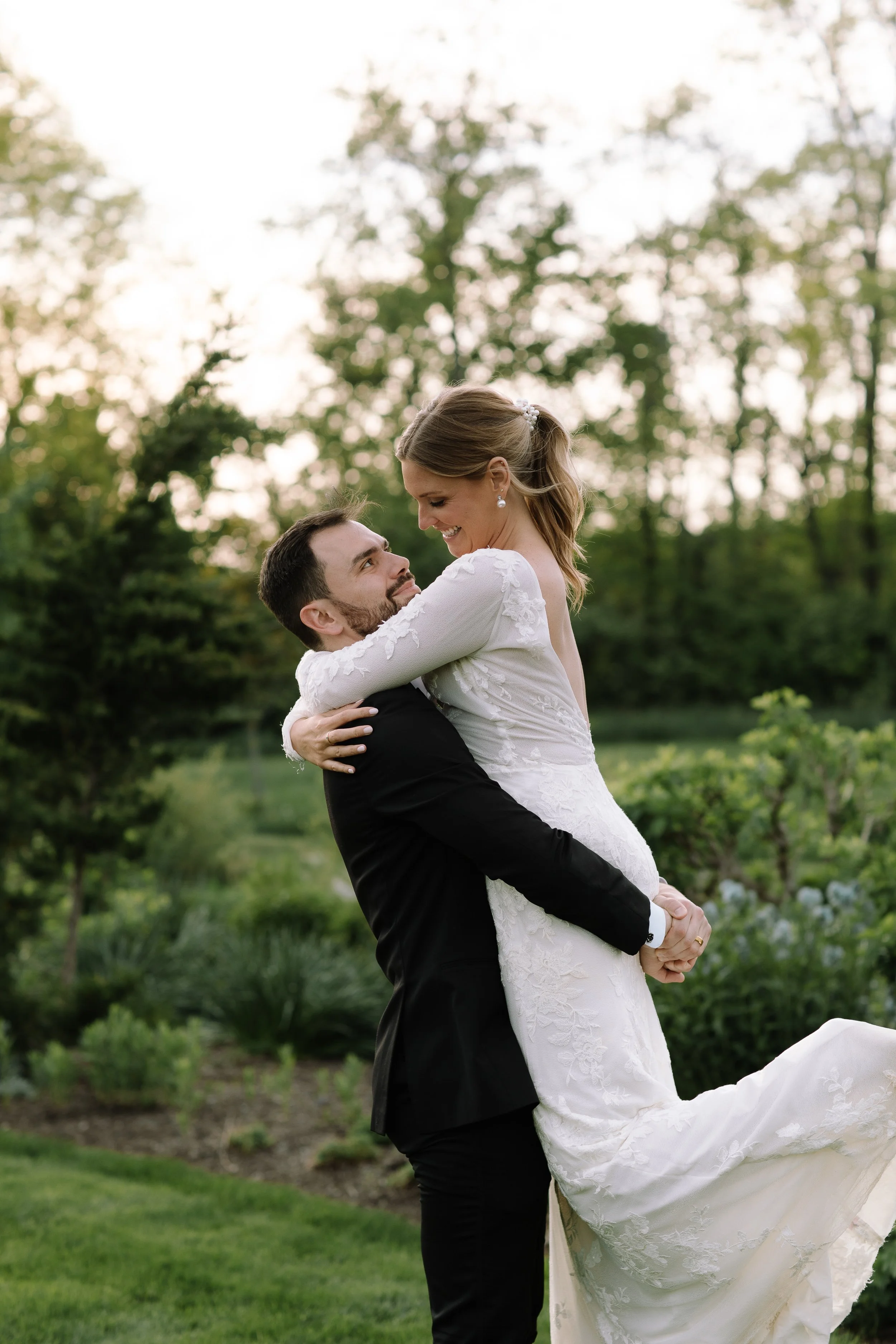 Groom lifting the bride during sunset portraits at Jorgensen Farm The Gardens in Columbus, Ohio.