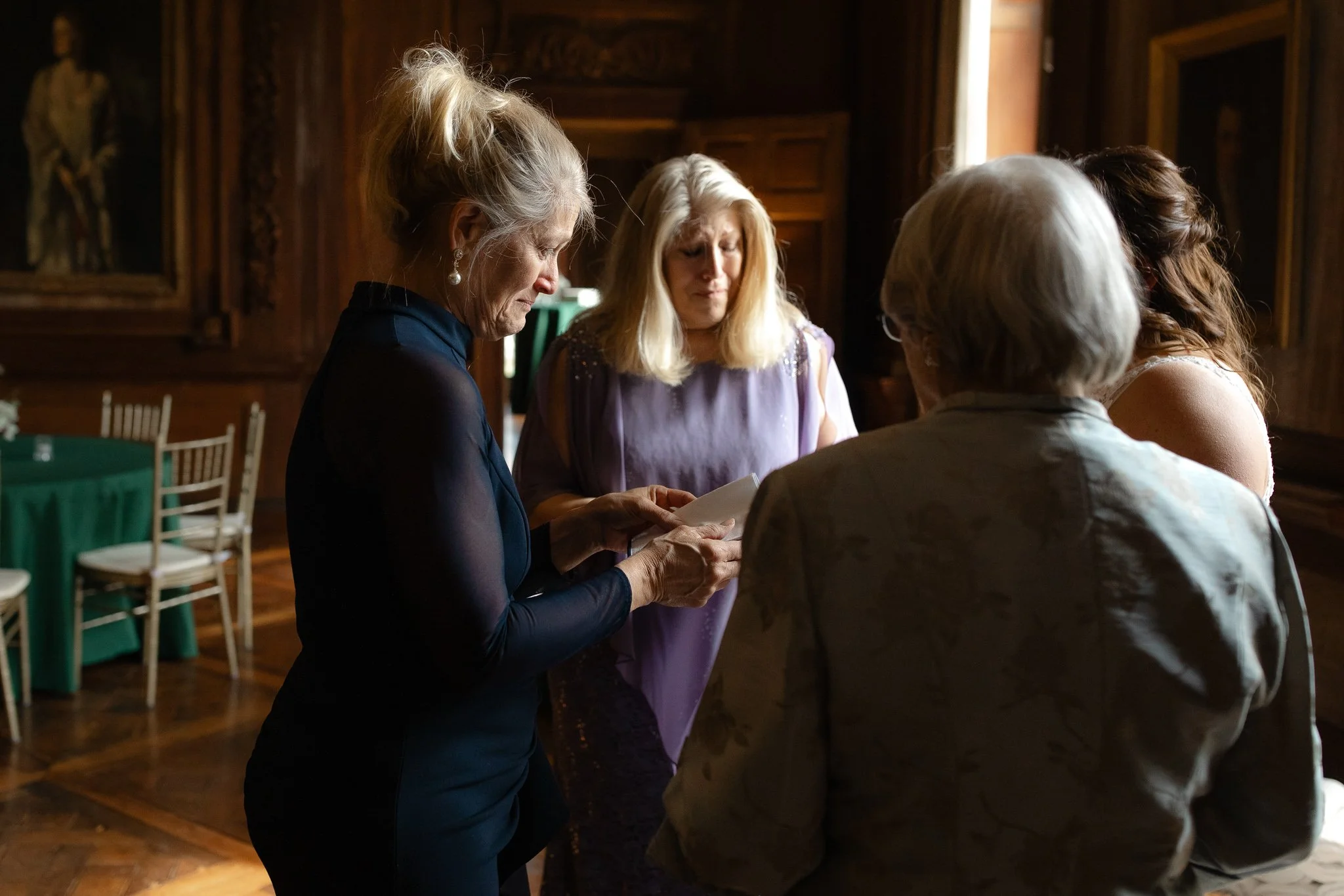 Family gathered in a circle reading letters inside Peterloon Estate grand room