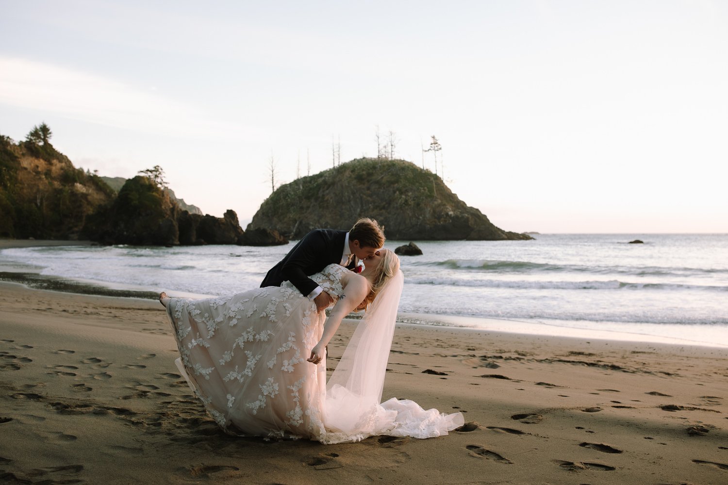 Bride and groom kissing at sunset on College Cove Beach in Trinidad California