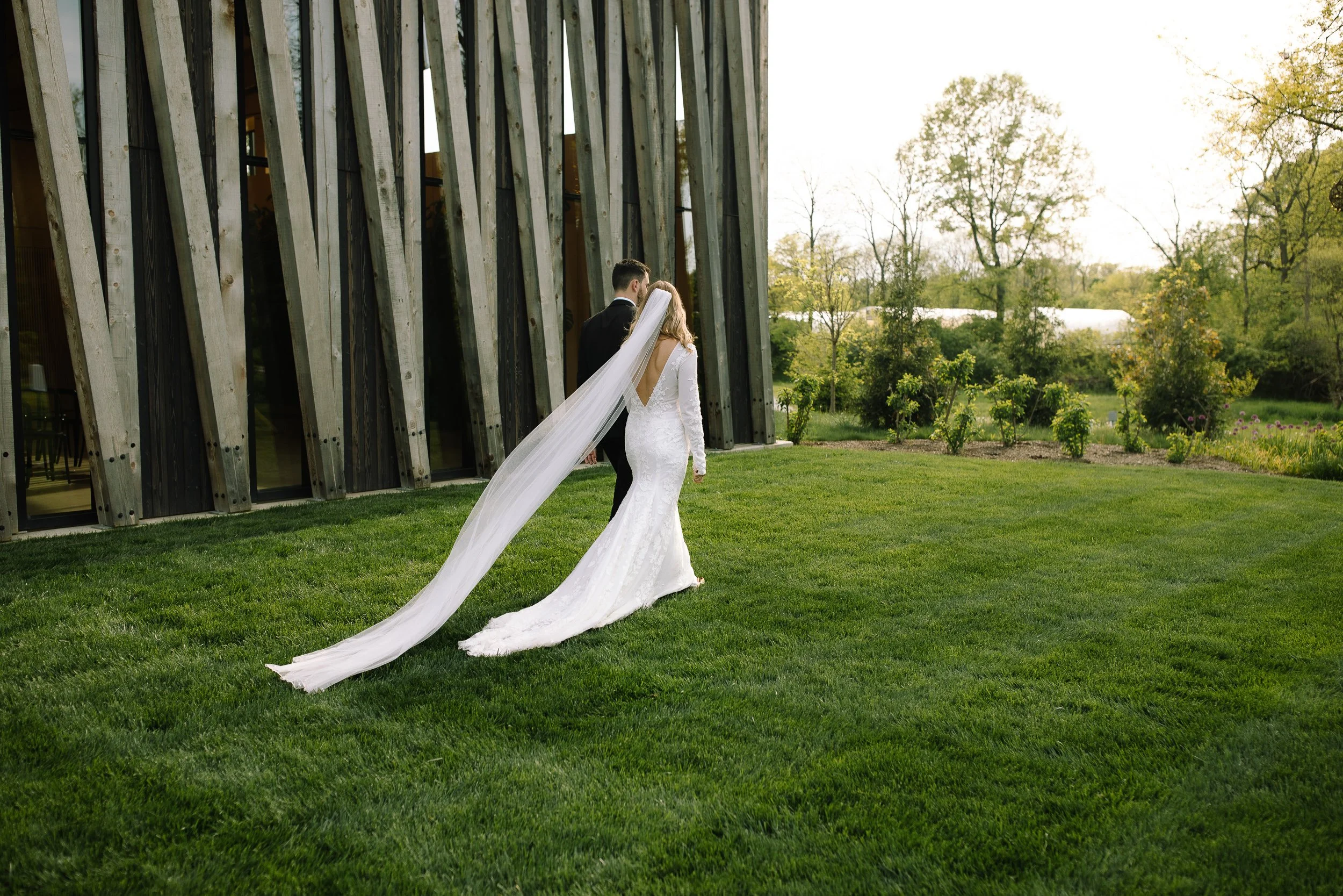 Bride and groom standing on the lawn outside the Arboretum building at Jorgensen Farm The Gardens in Columbus, Ohio.