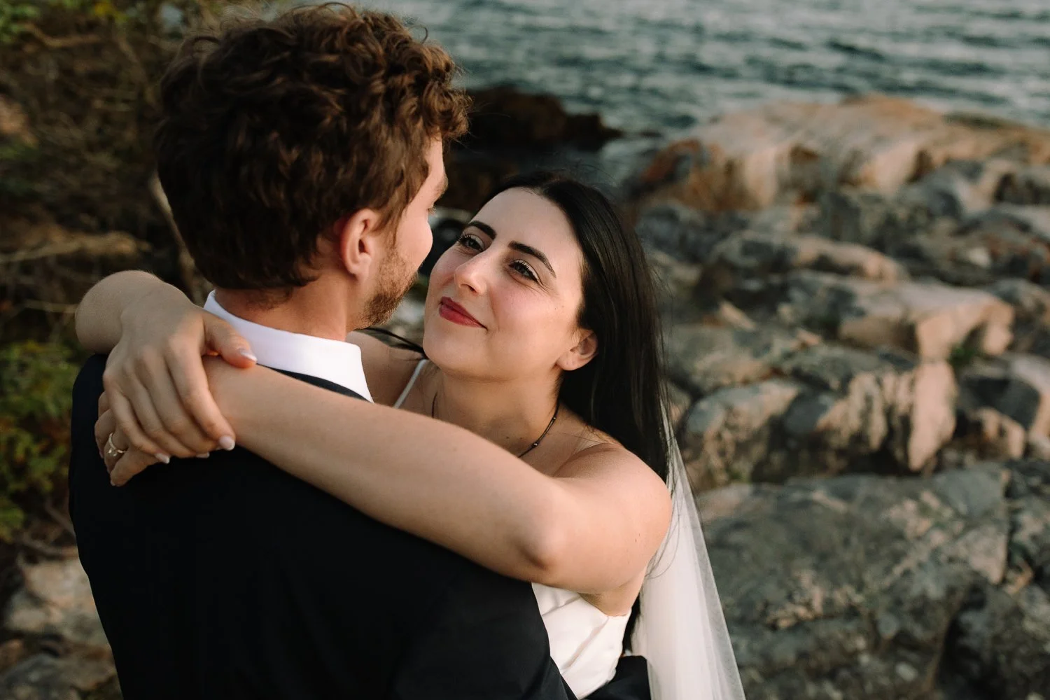 Close, intimate portrait of a bride and groom embracing during their Acadia National Park elopement