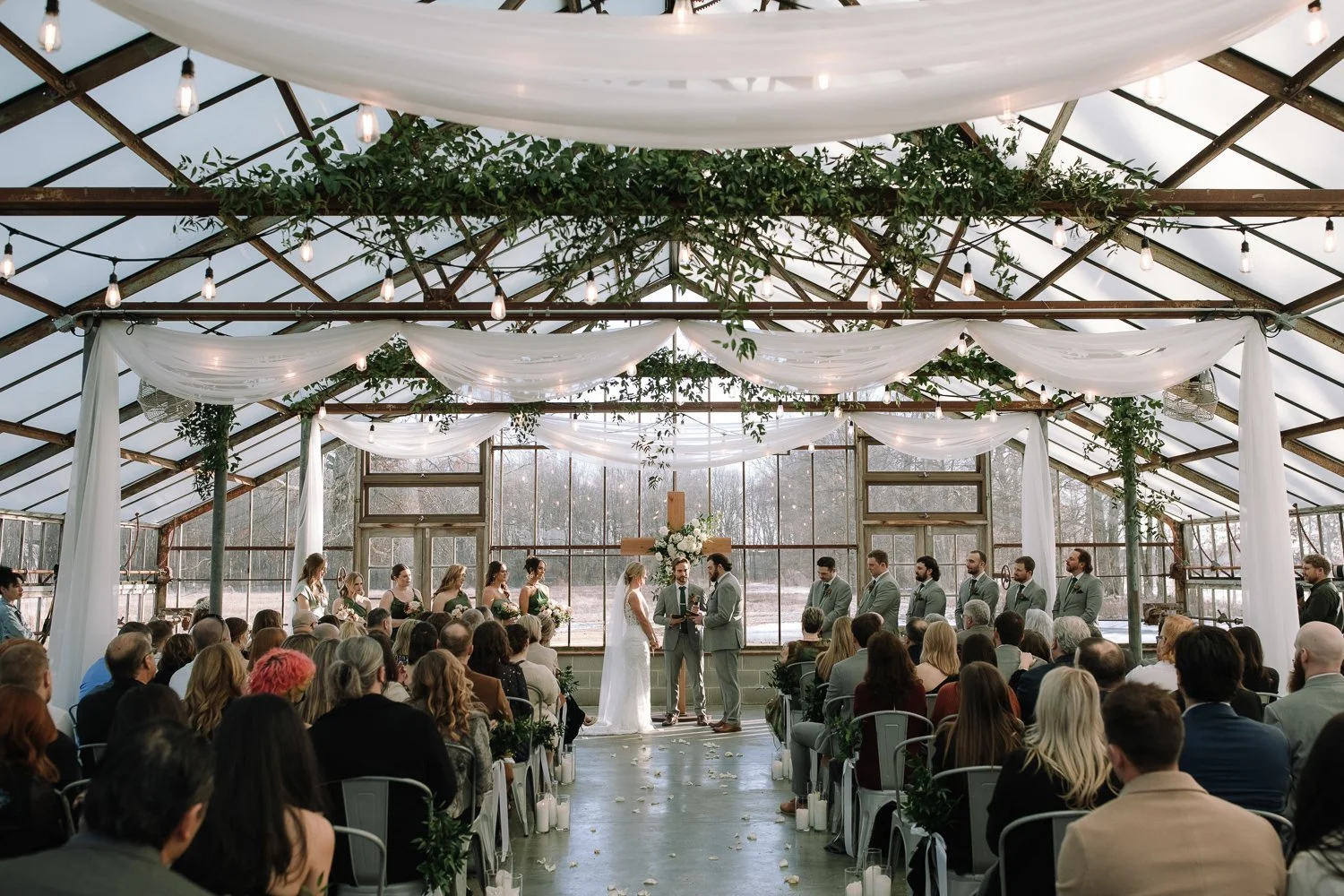 Indoor winter wedding ceremony inside Jorgensen Farms Greenhouse near Columbus, Ohio