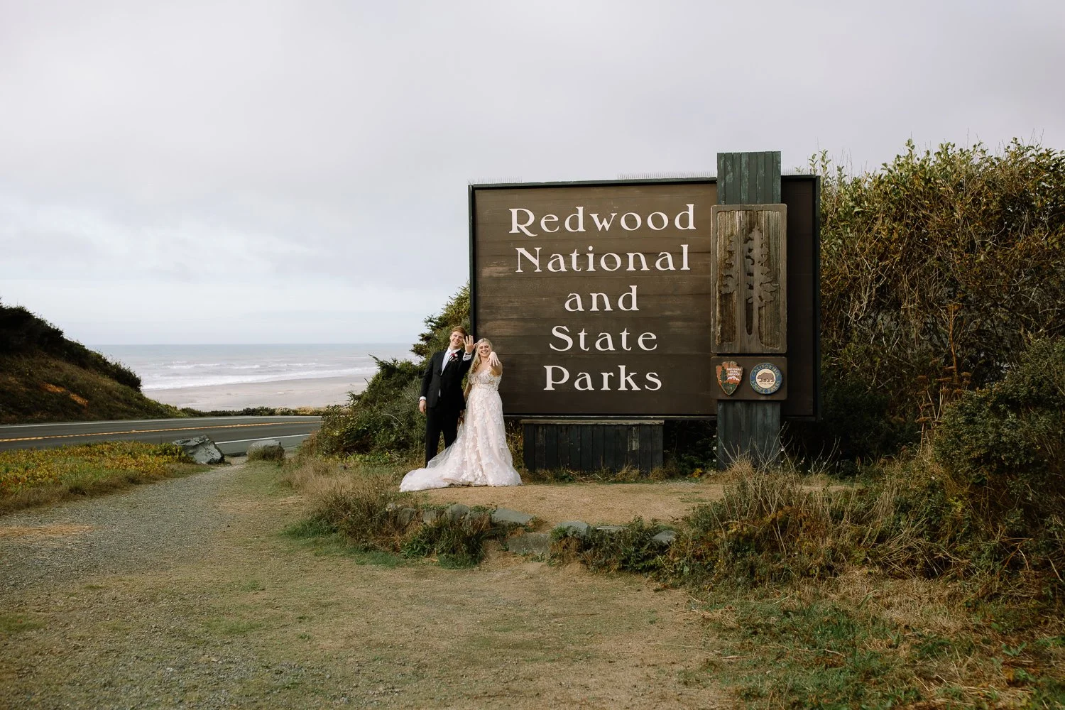 Bride and groom standing by Redwood National and State Parks sign