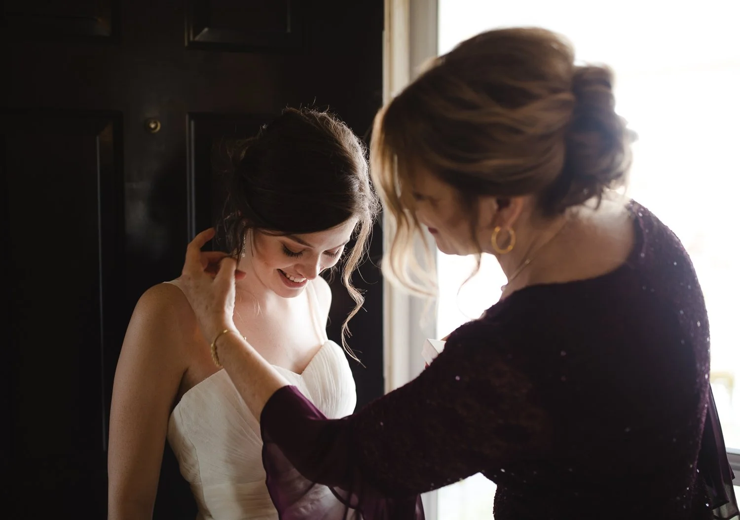 Mother adjusting the bride’s necklace during quiet getting ready moments before the ceremony