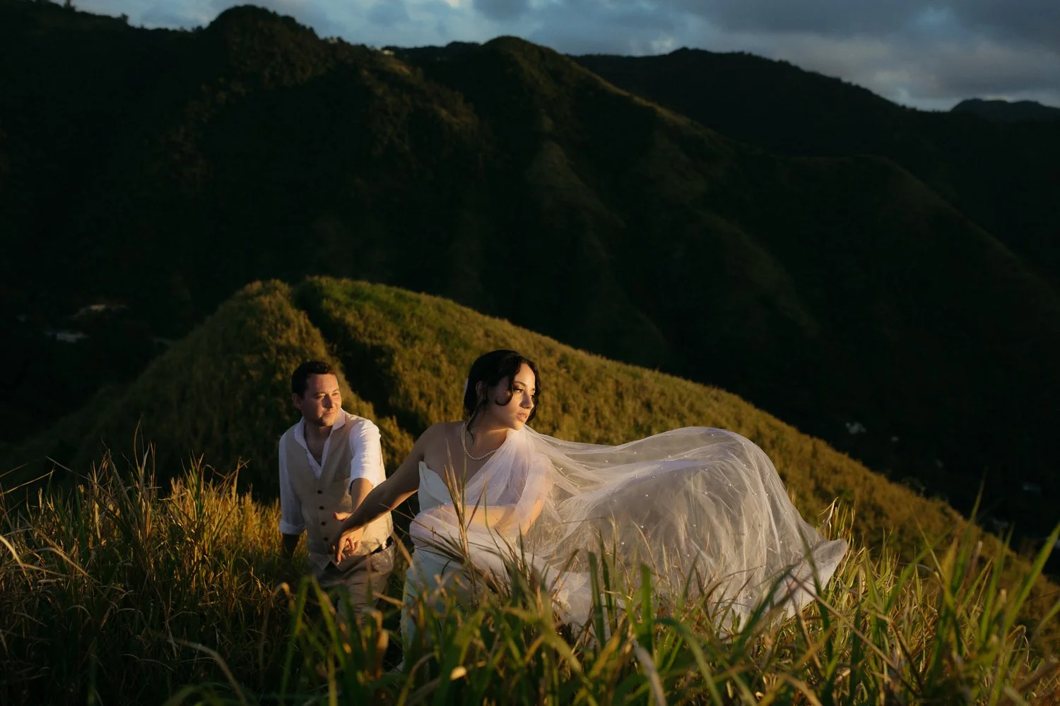 Couple walking through tall grass during a mountain elopement photo session at Cerro Mime in Puerto Rico at sunset
