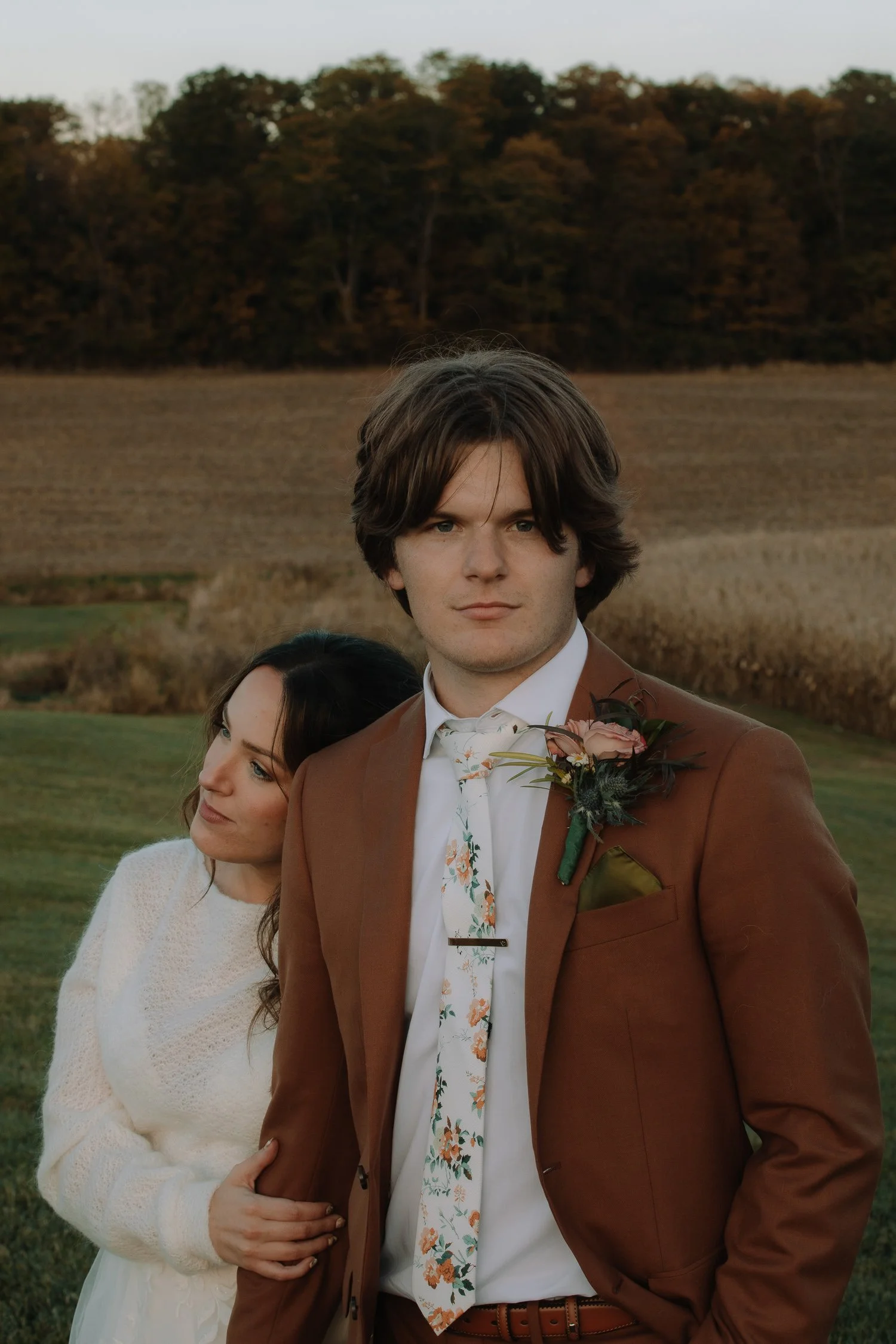 Romantic autumn wedding portrait of the groom with the bride leaning in beside him at Ivory Meadows in Dayton, Ohio during golden hour.