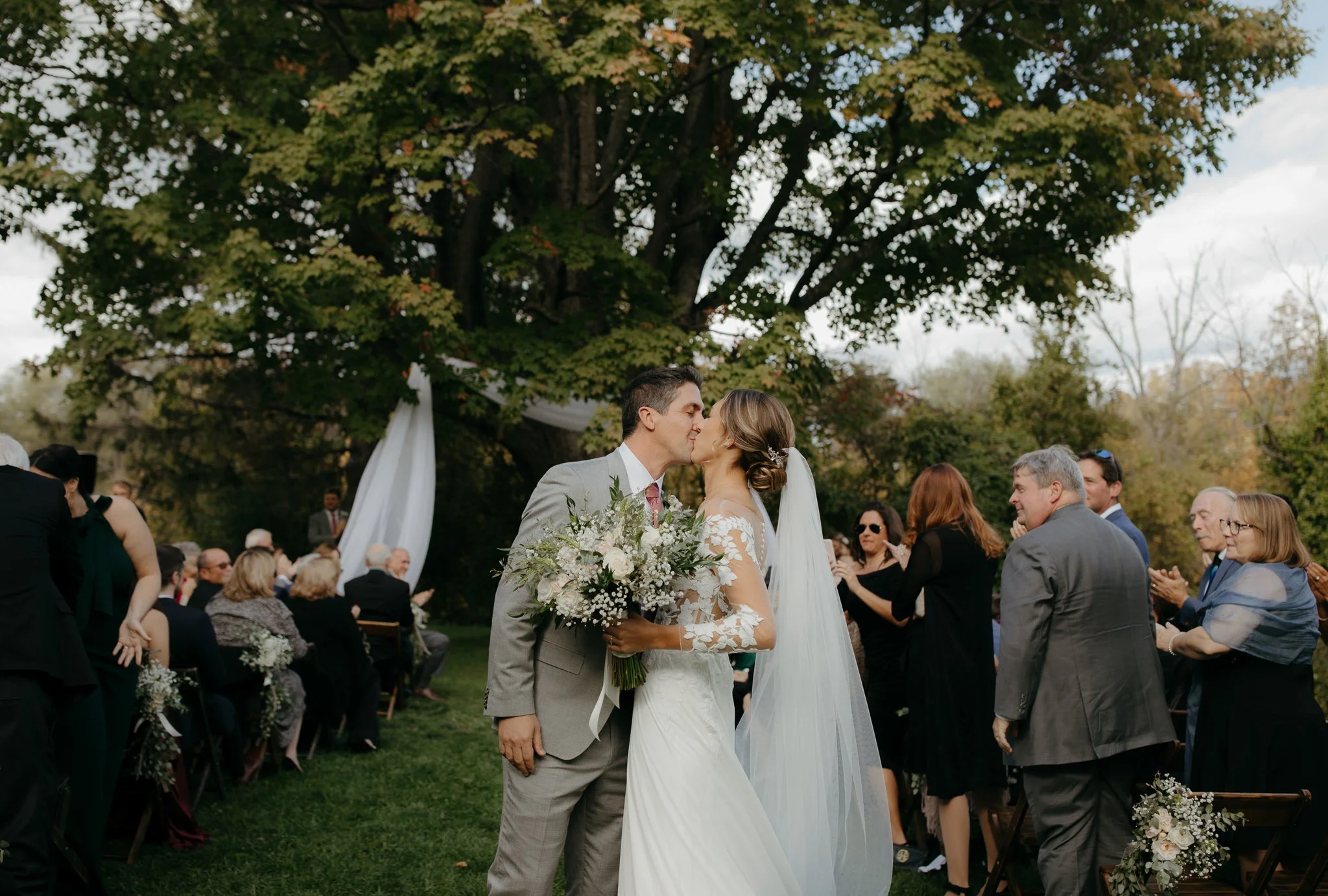 Bride and groom sharing their first kiss after their outdoor ceremony at Windrift Hall in the Hudson Valley