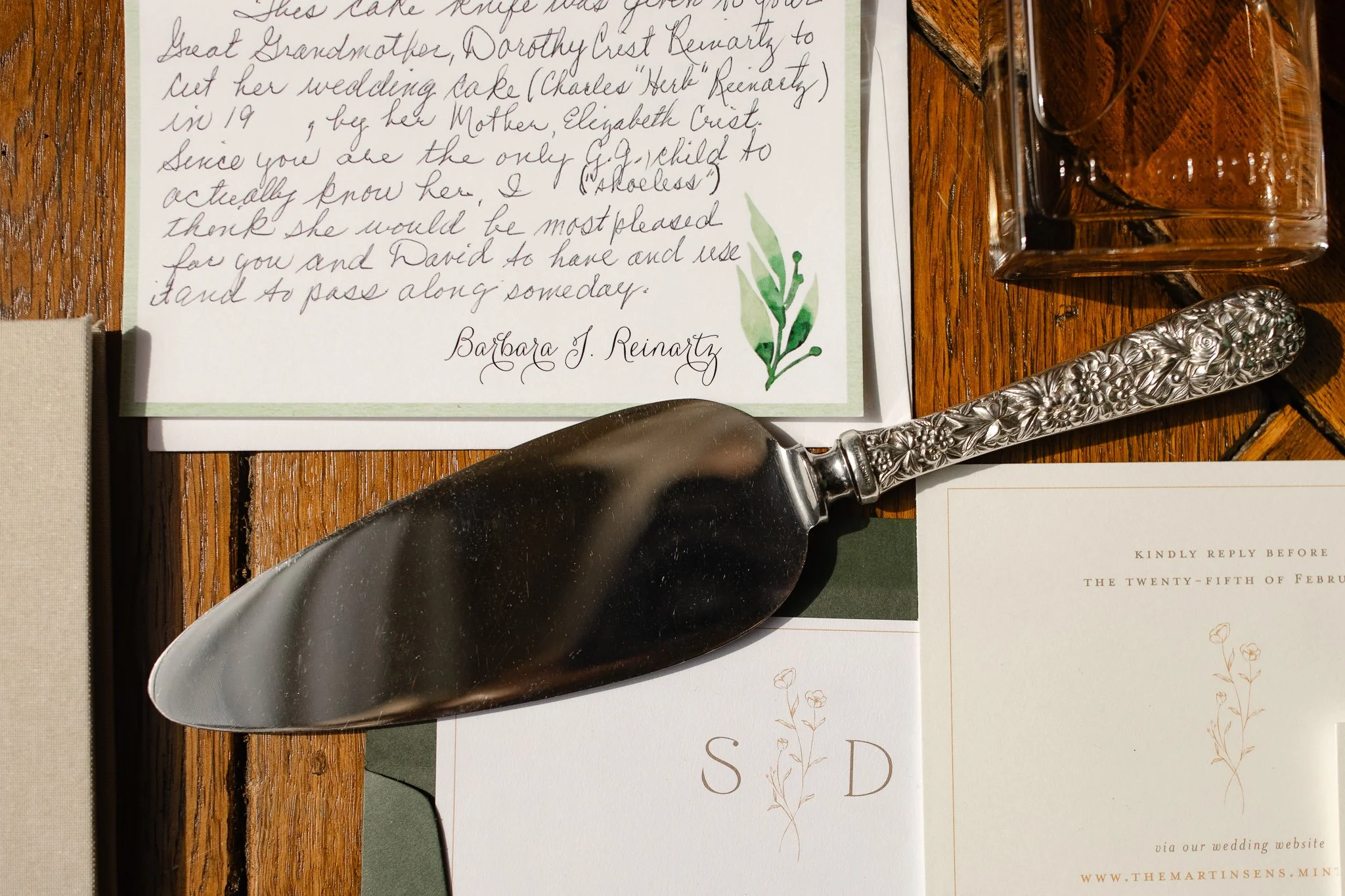 Wedding invitation and vintage cake server detail photographed on wood surface