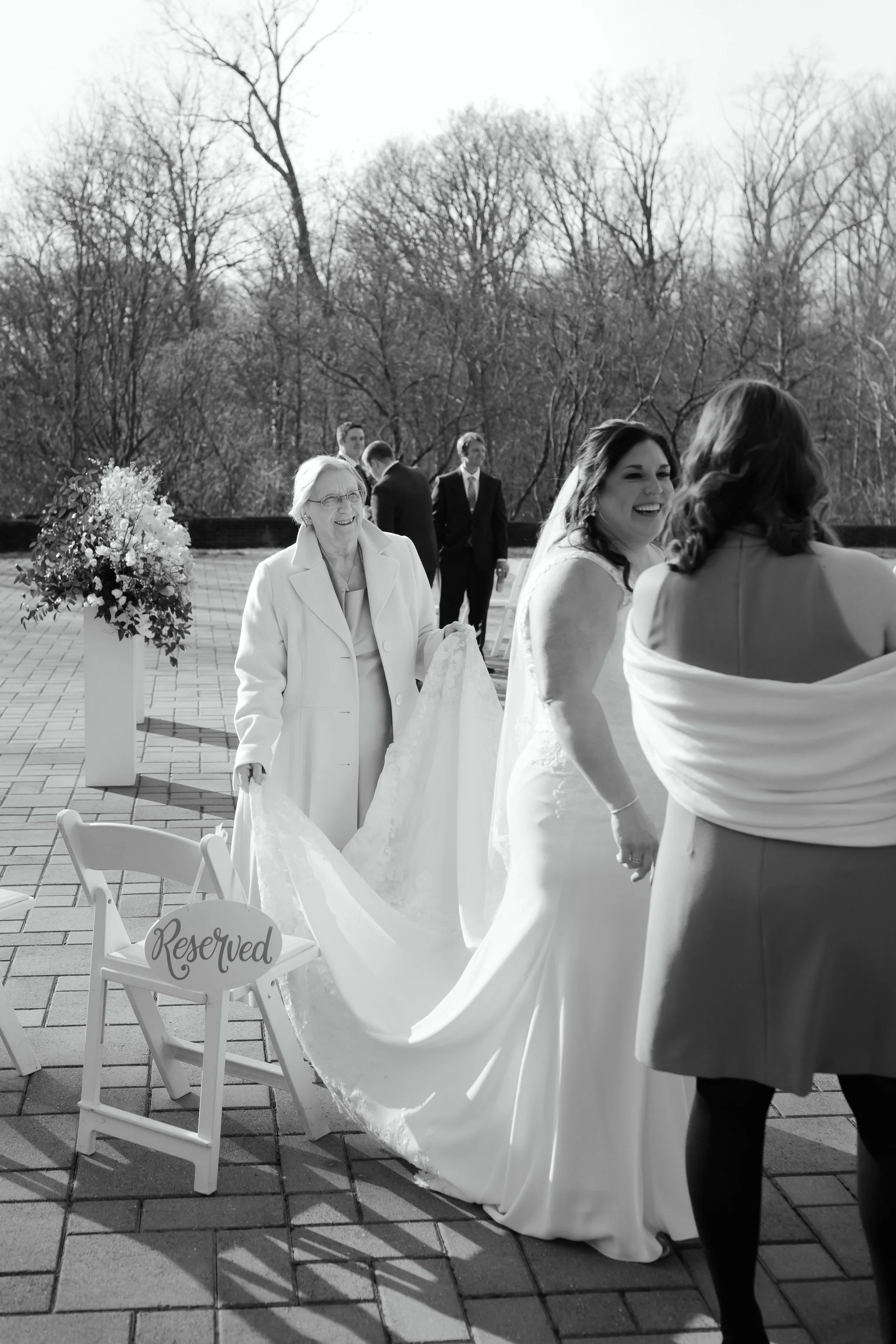 Grandmother holding bride’s dress train after ceremony