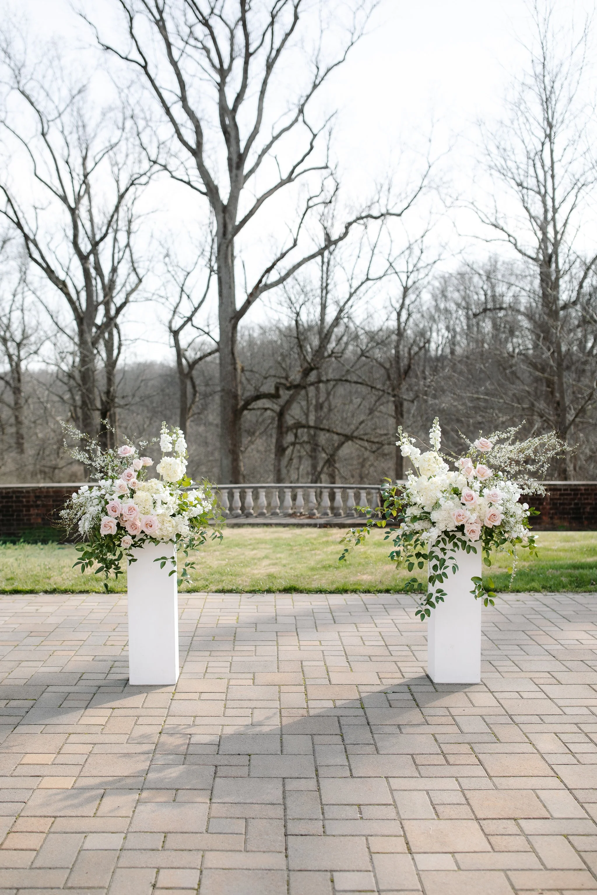 Floral arrangements on pedestals set for terrace ceremony at Peterloon Estate
