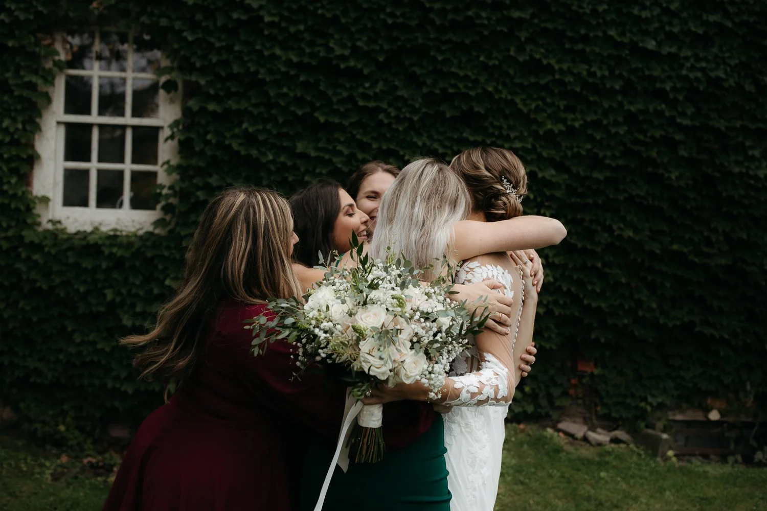 Bride hugging friends during cocktail hour at Windrift Hall in the Hudson Valley