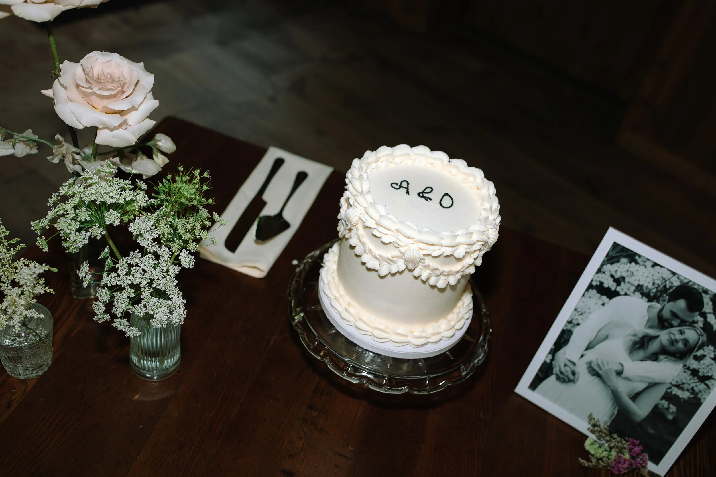 Simple white wedding cake displayed inside the historic barn at Jorgensen Farms.