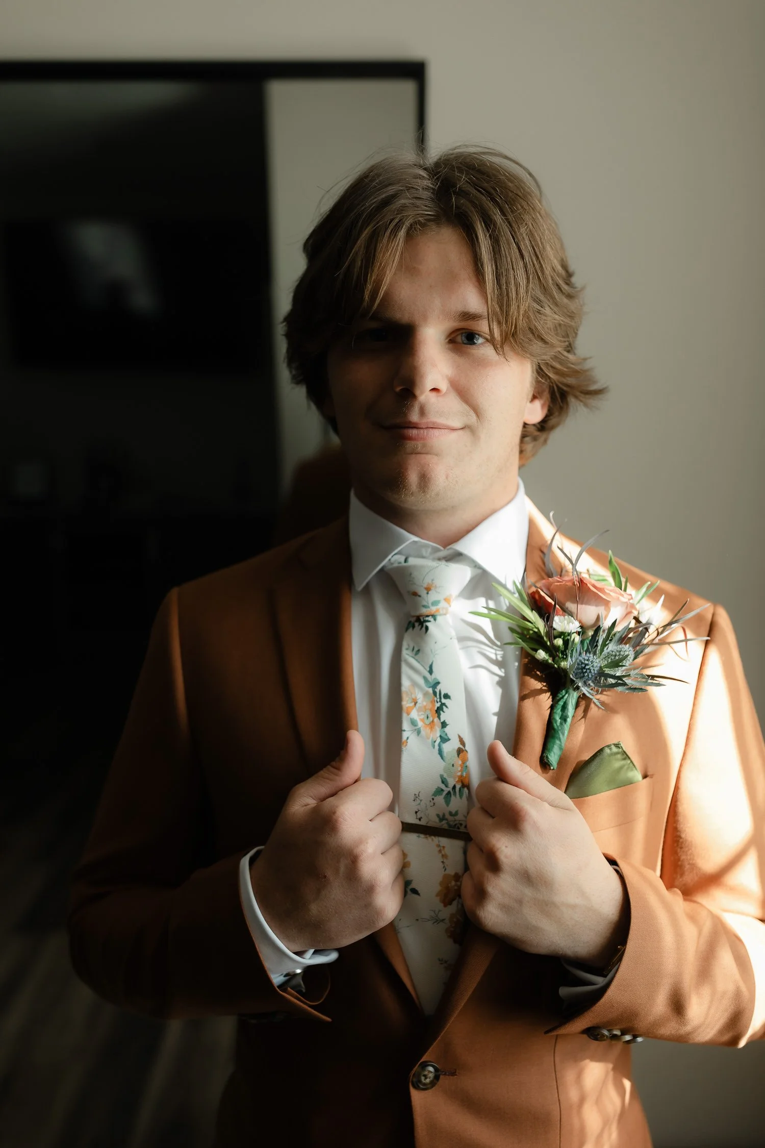 Portrait of the groom wearing a boutonniere during getting ready at Ivory Meadows in Yellow Springs, Ohio.