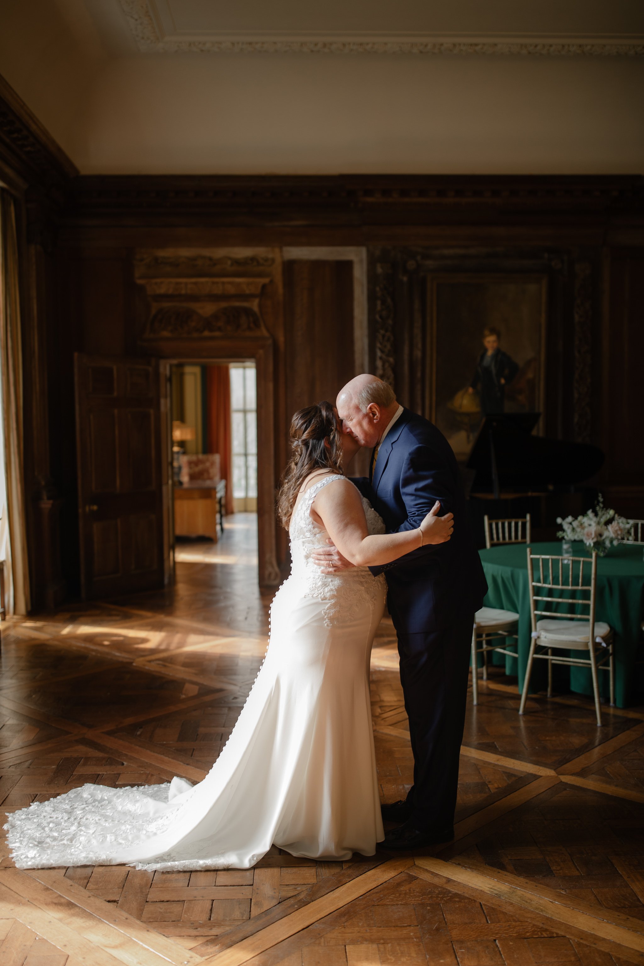 Bride and father embracing during first look inside Peterloon Estate grand room