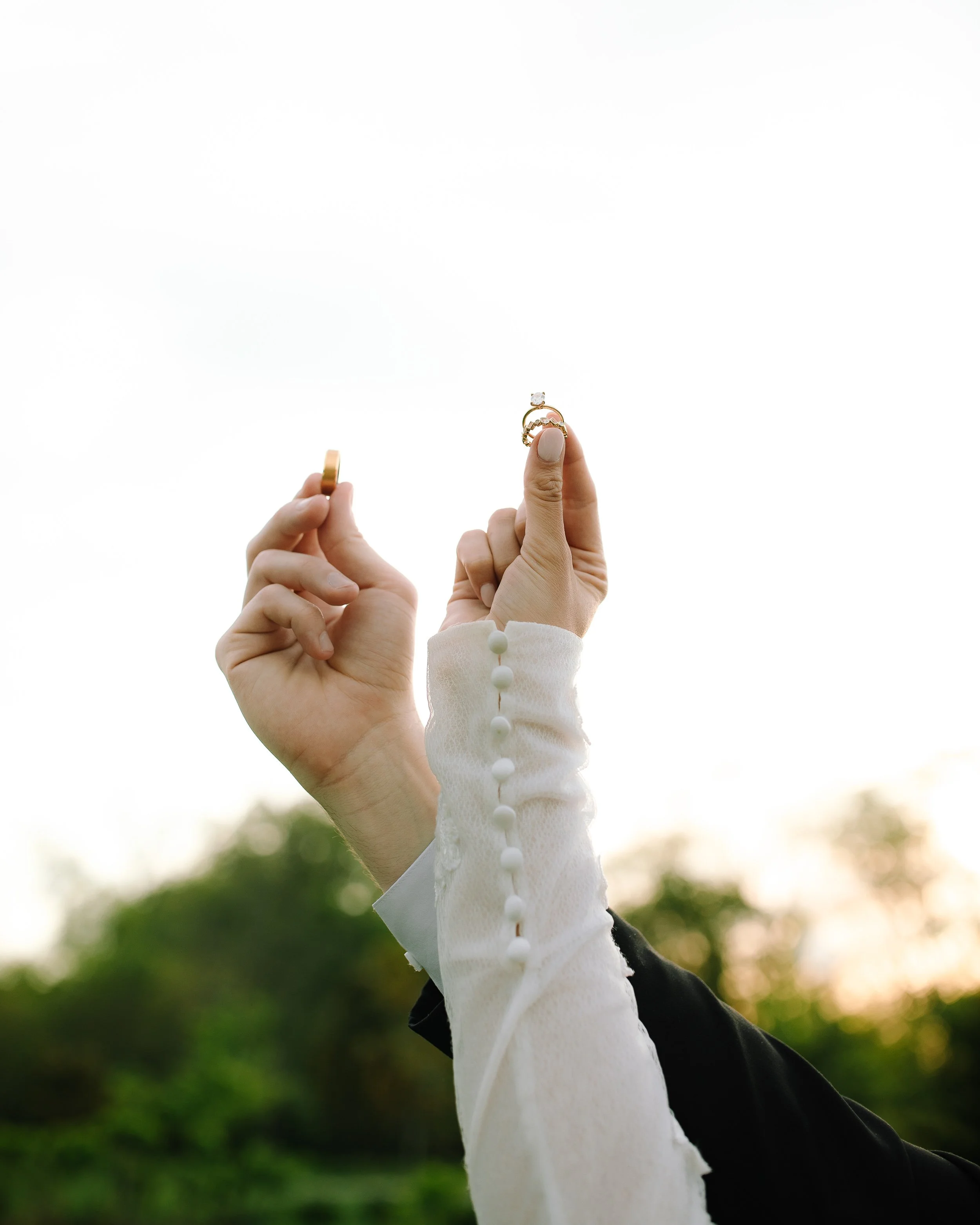 Bride holding her wedding rings up in soft evening light during a spring wedding at Jorgensen Farm The Gardens in Columbus, Ohio.
