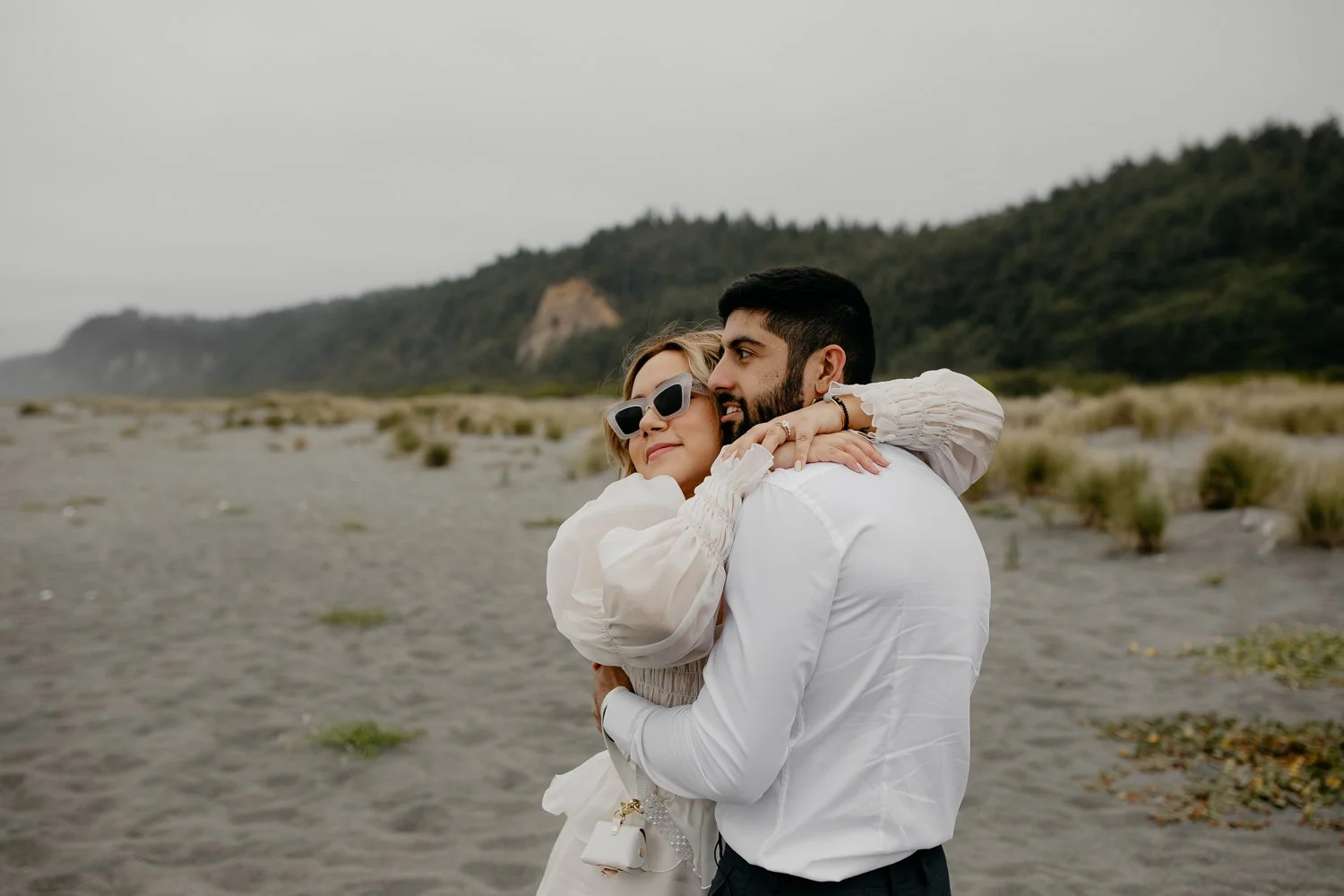 Couple embracing on a quiet beach near Prairie Creek Redwoods