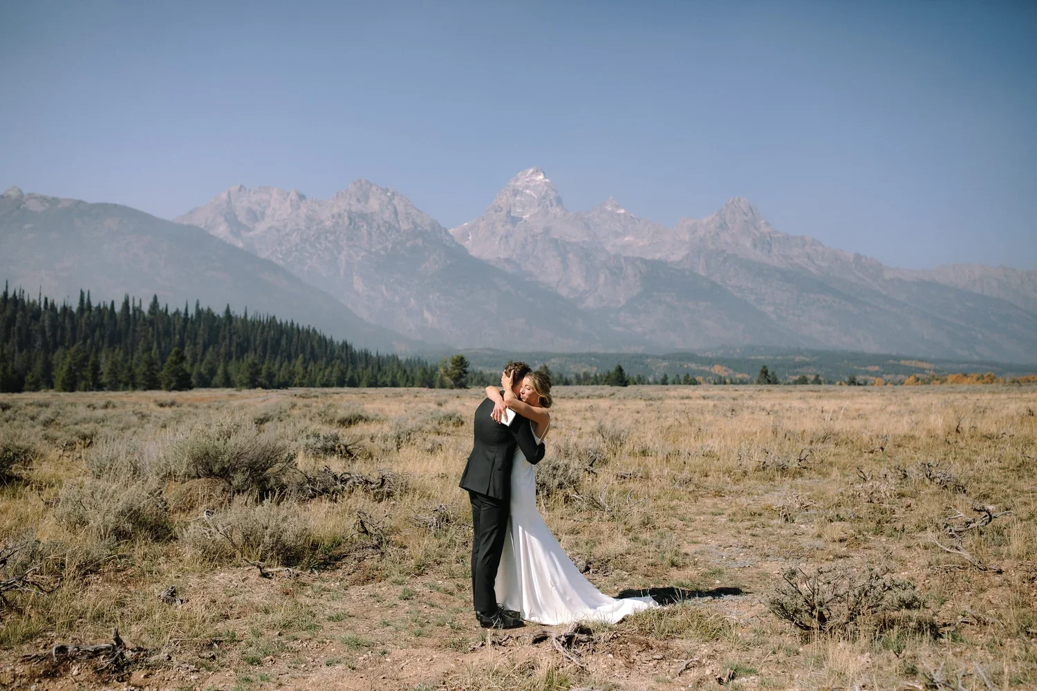 Couple sharing a private first look during their Jackson Hole wedding with mountain views behind them.