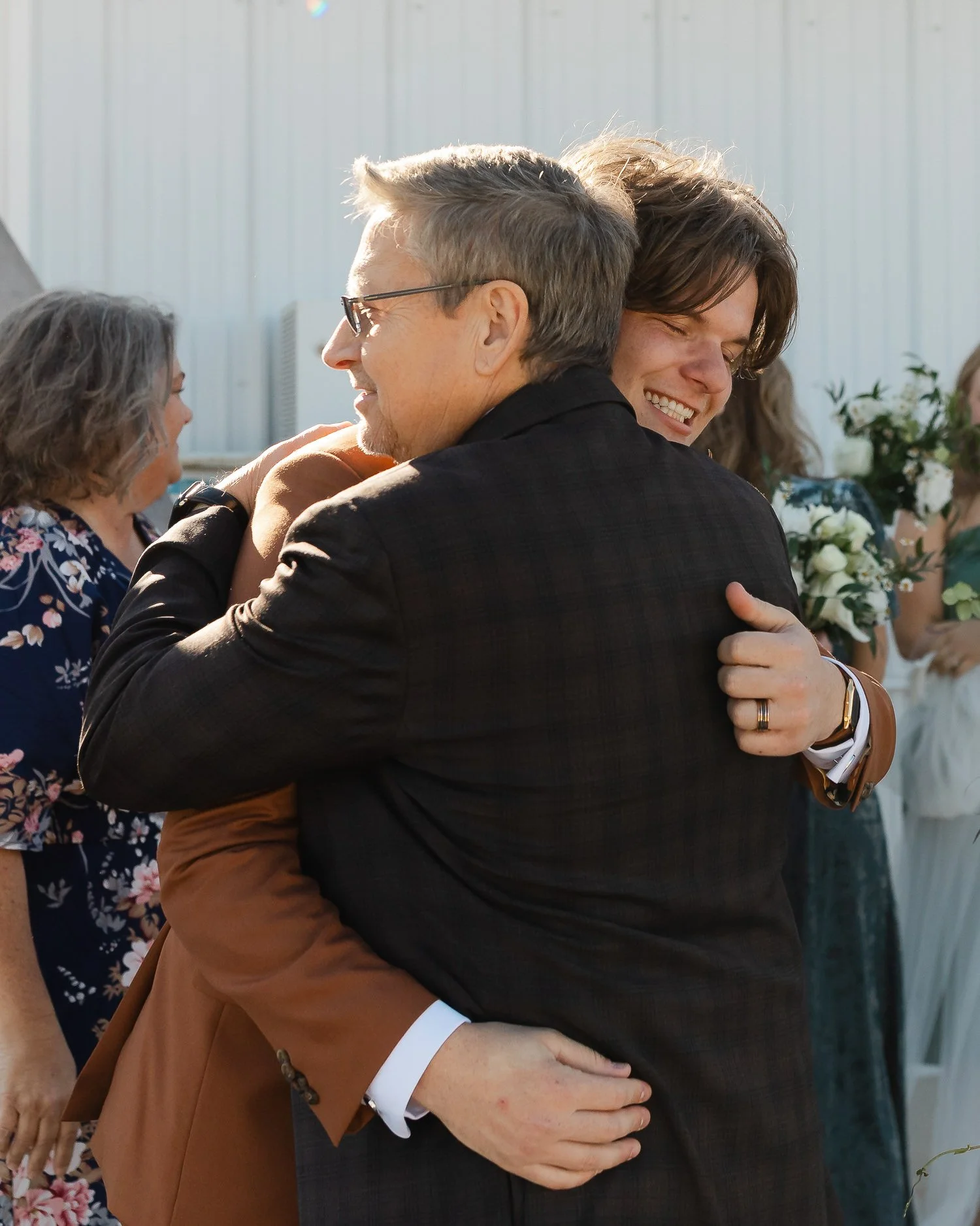 Groom sharing a heartfelt hug with a family member following the ceremony at Ivory Meadows in Dayton, Ohio.
