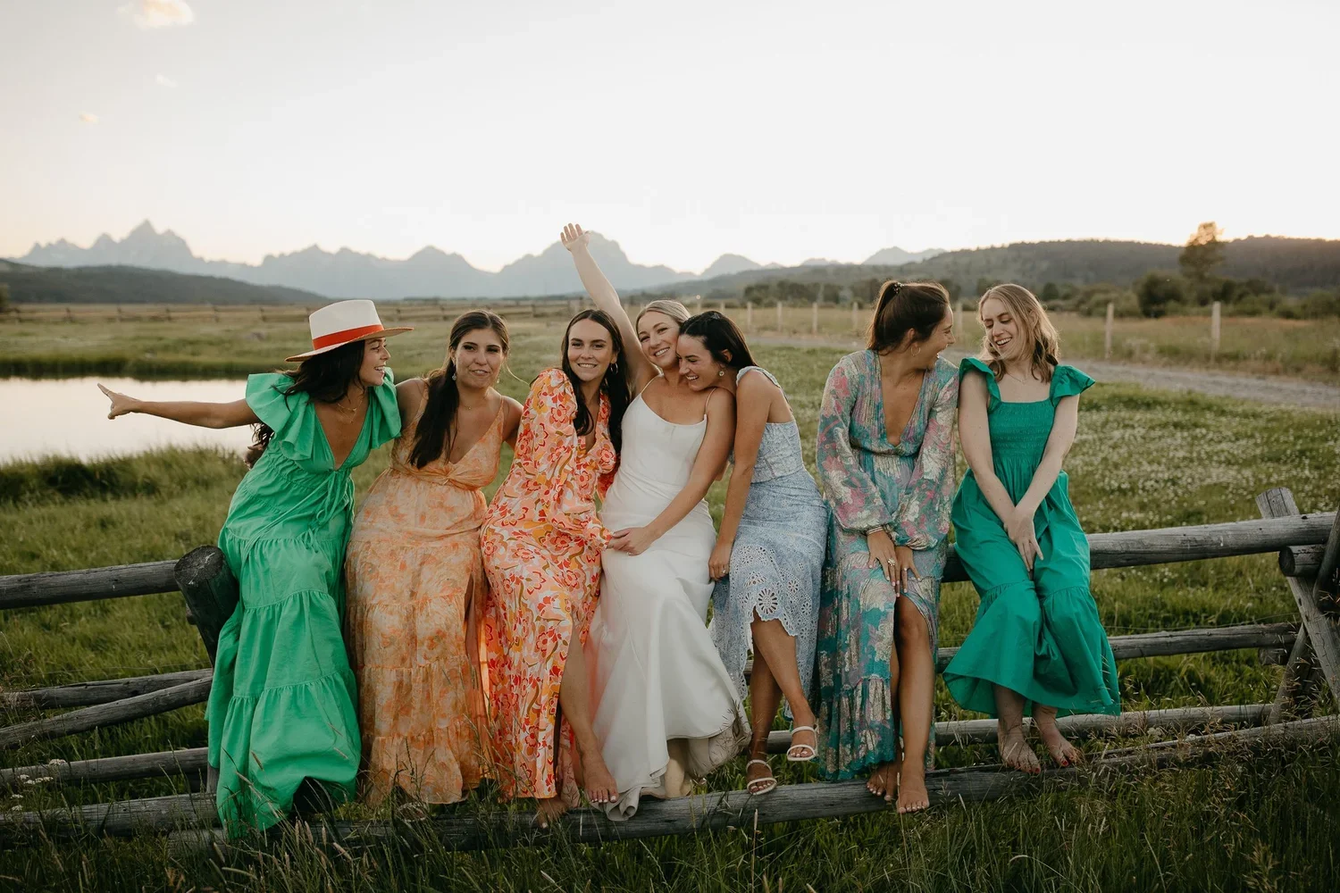 Bride sitting with her friends at Diamond Cross Ranch in Jackson Hole with the Teton Mountains in the distance