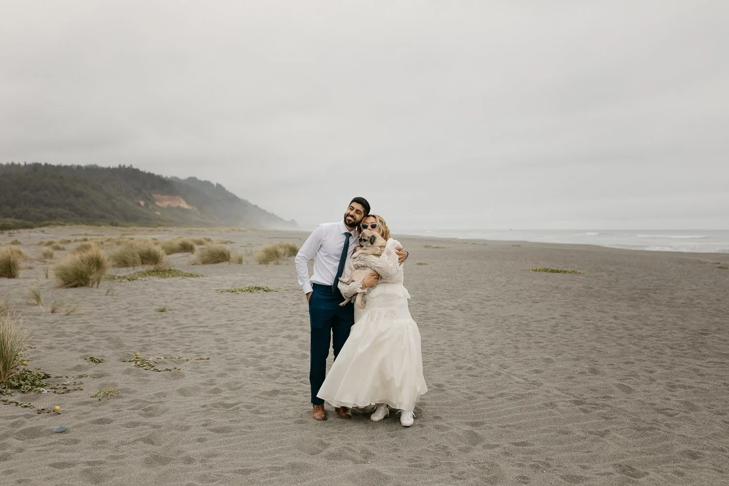 Couple holding their dog during an intimate beach elopement on the Southern Oregon Coast