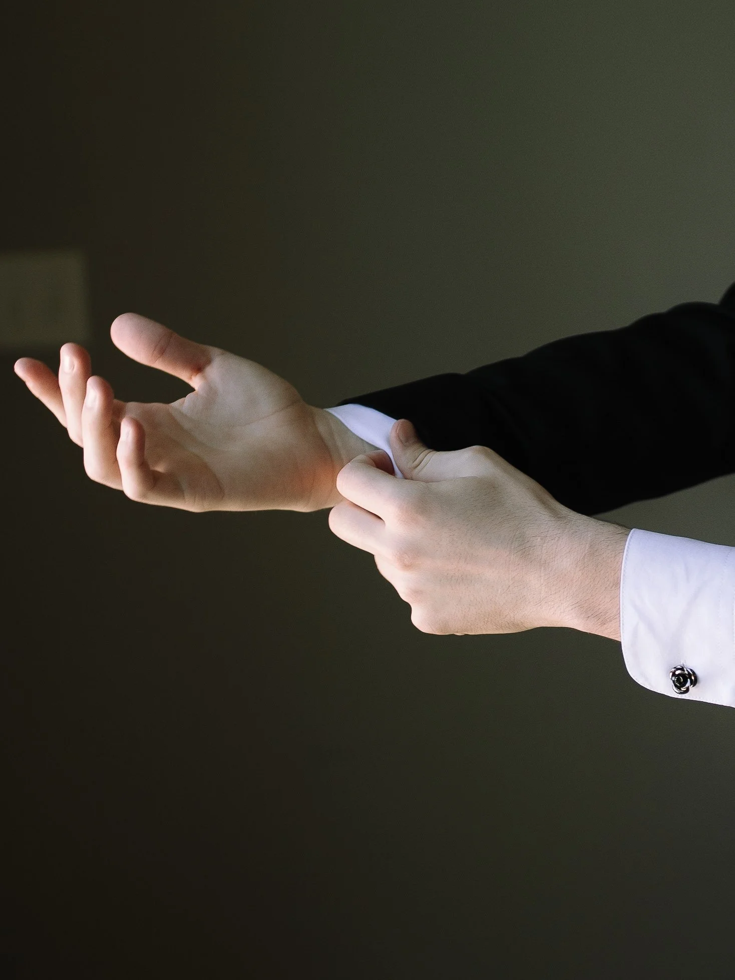Close-up of groom adjusting his cufflinks before his spring wedding at Jorgensen Farm The Gardens.