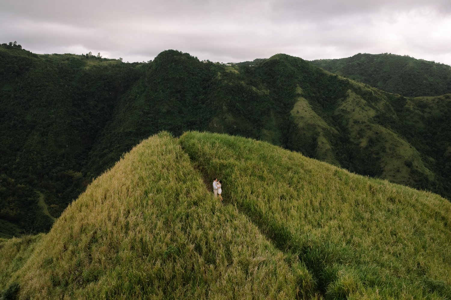 Couple standing together on a grassy mountain ridge during an elopement photo session in Puerto Rico