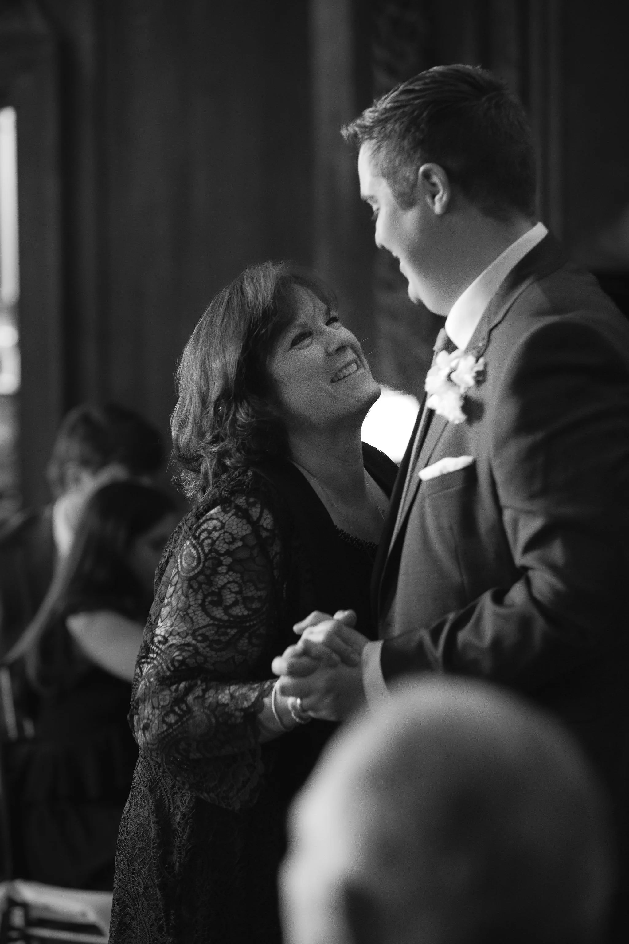 Mother and son dancing together during reception in black and white