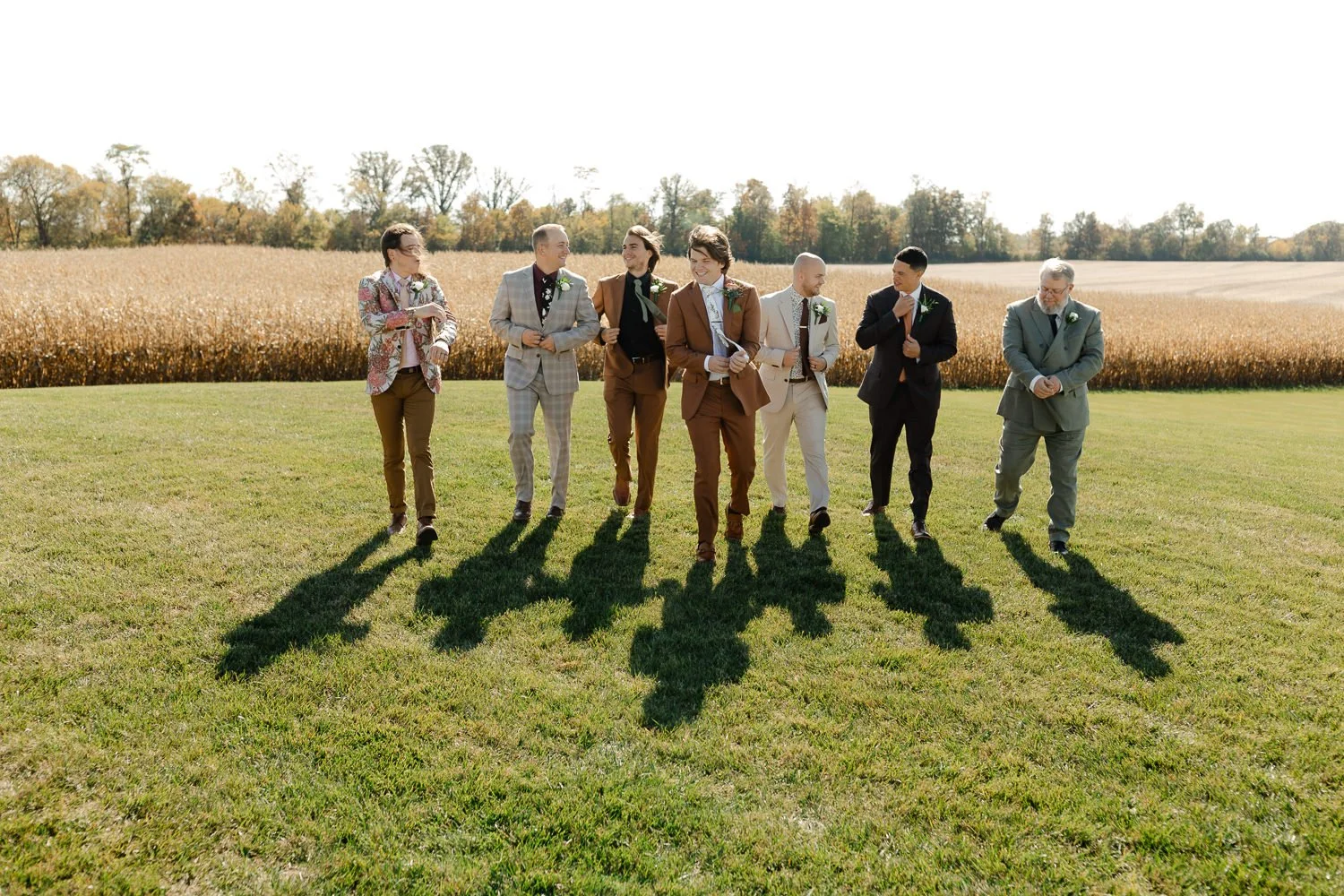Groomsmen walking together across an open field during portraits at Ivory Meadows in Yellow Springs, Ohio.