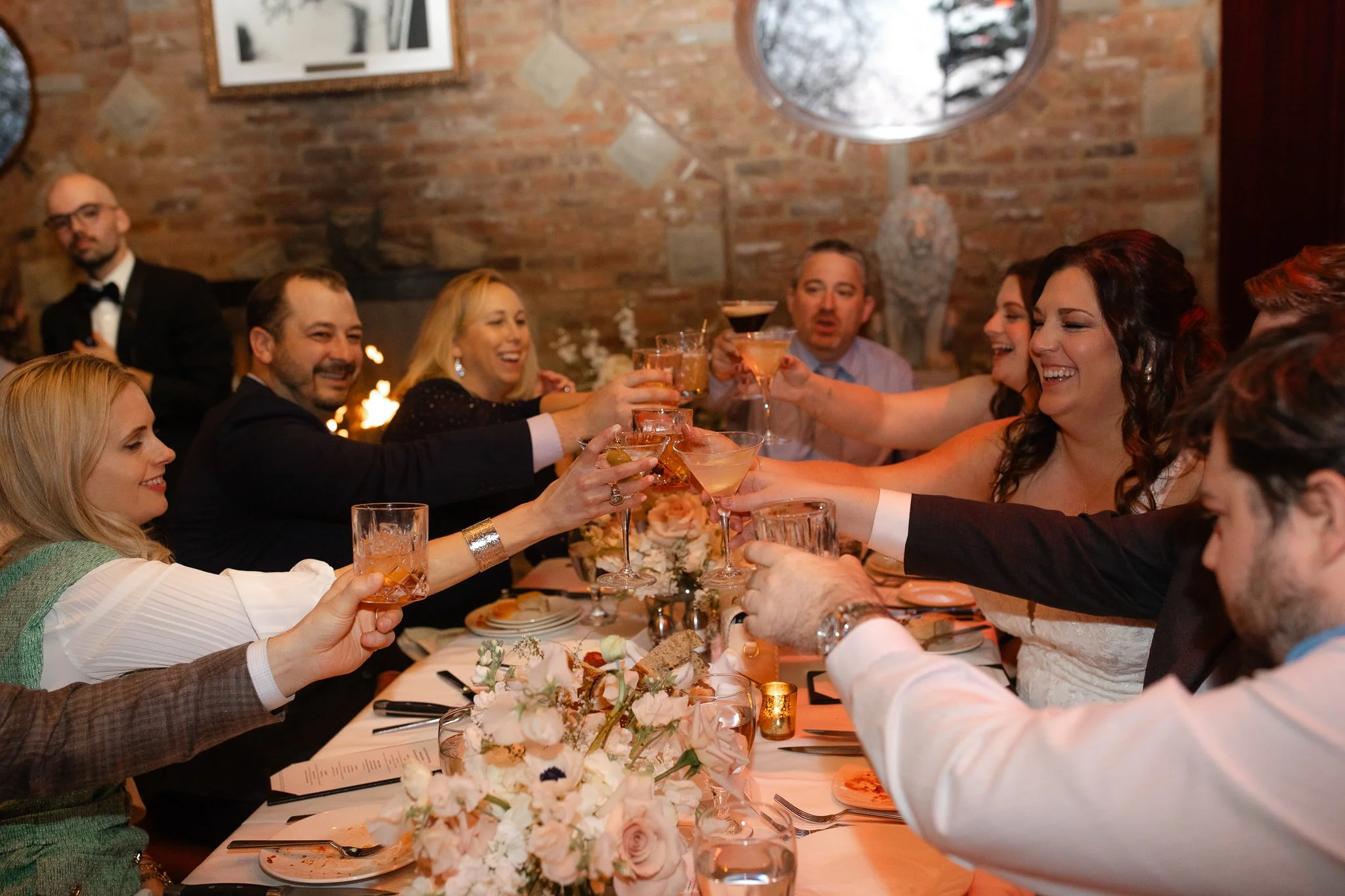 Guests raising glasses together during wedding dinner at Carlo and Johnny