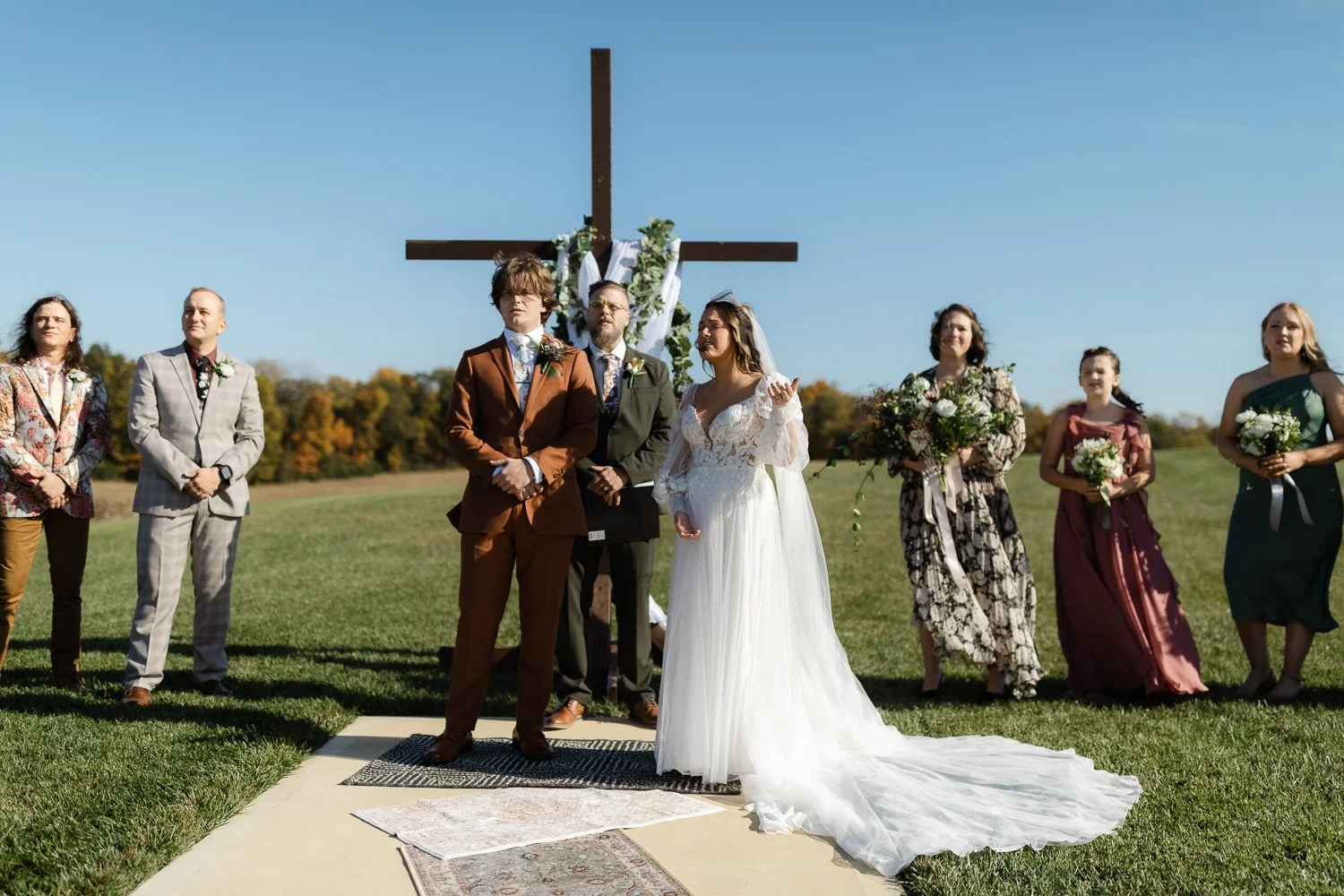 Bride and groom worshipping together during a worship song at their outdoor wedding ceremony at Ivory Meadows near Dayton, Ohio